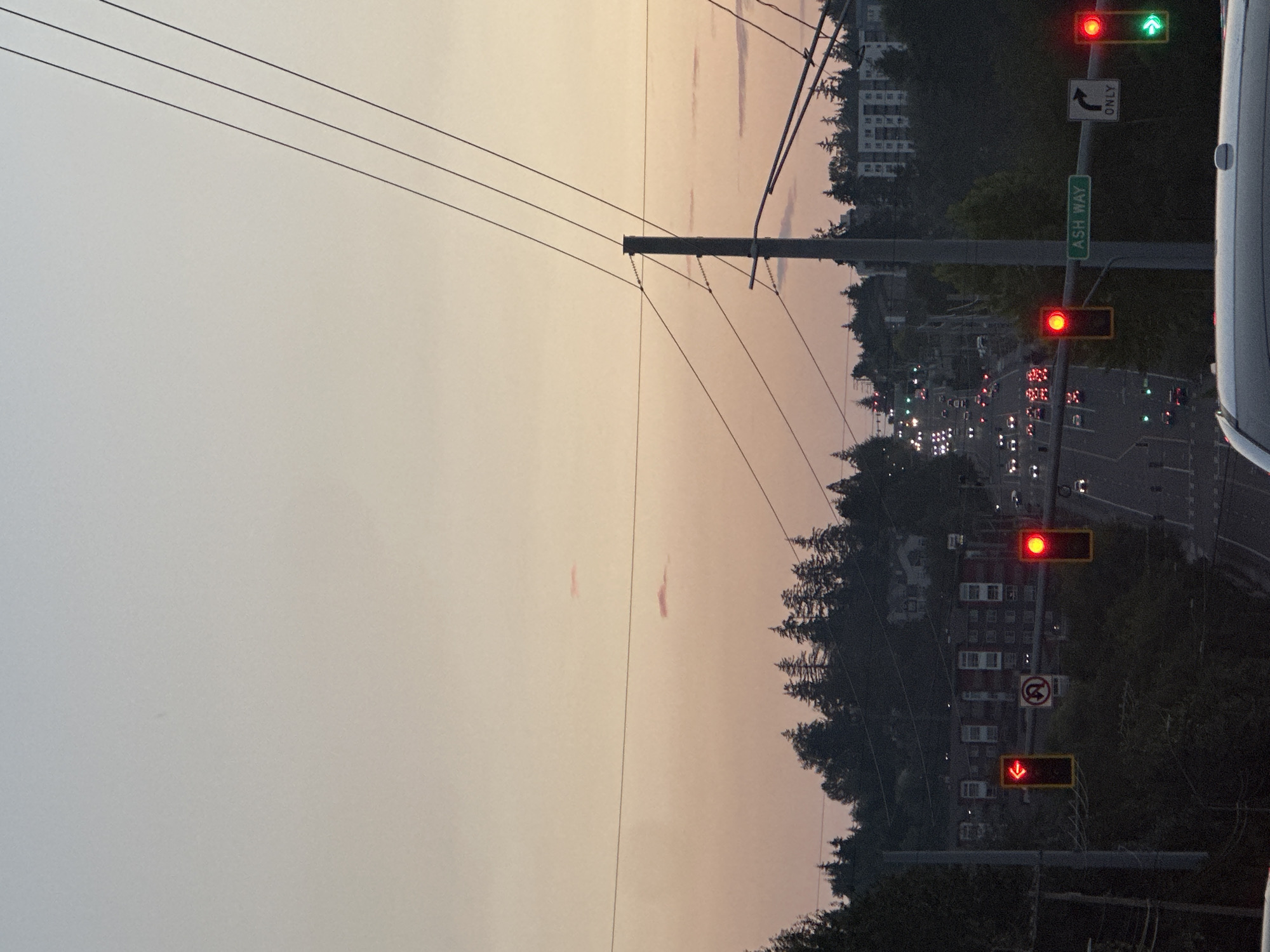 Evening traffic and signage on a North Lynnwood commercial strip