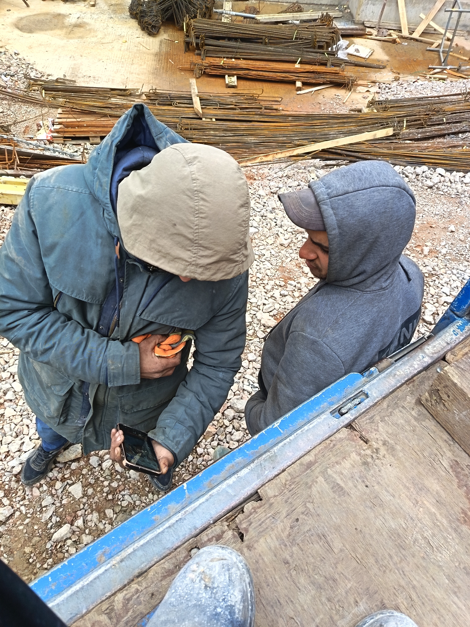 Construction workers take phone break at Sofia building site