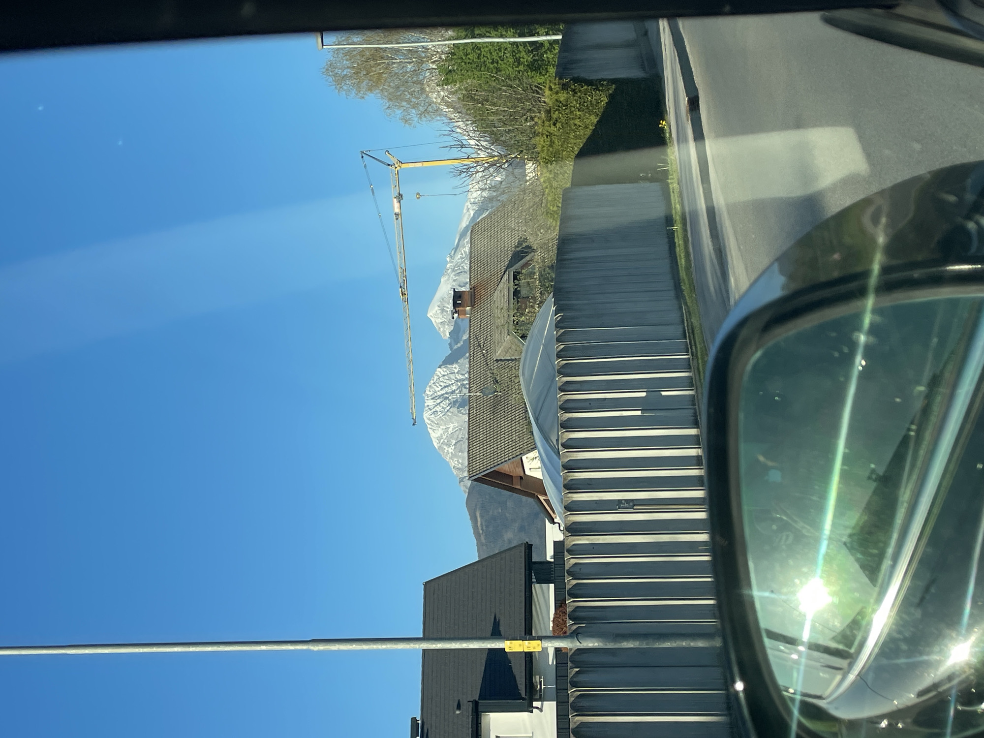 Mountain view with construction crane spotted from car in Kranj