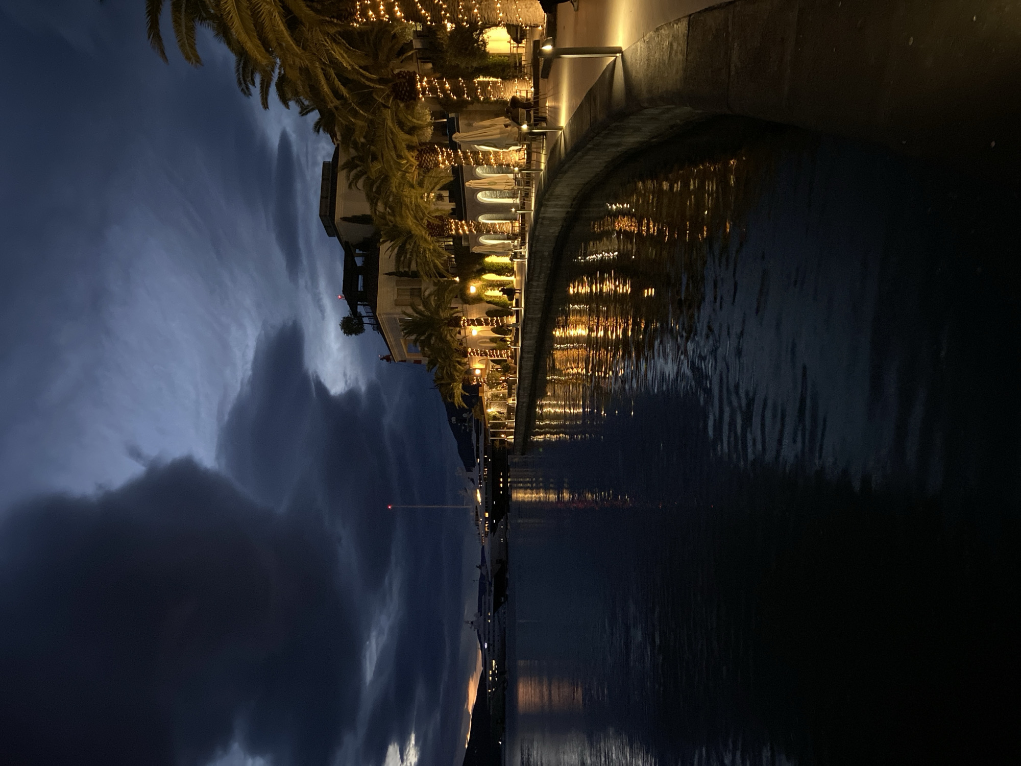Couple documents evening stroll through illuminated Porto Montenegro marina district