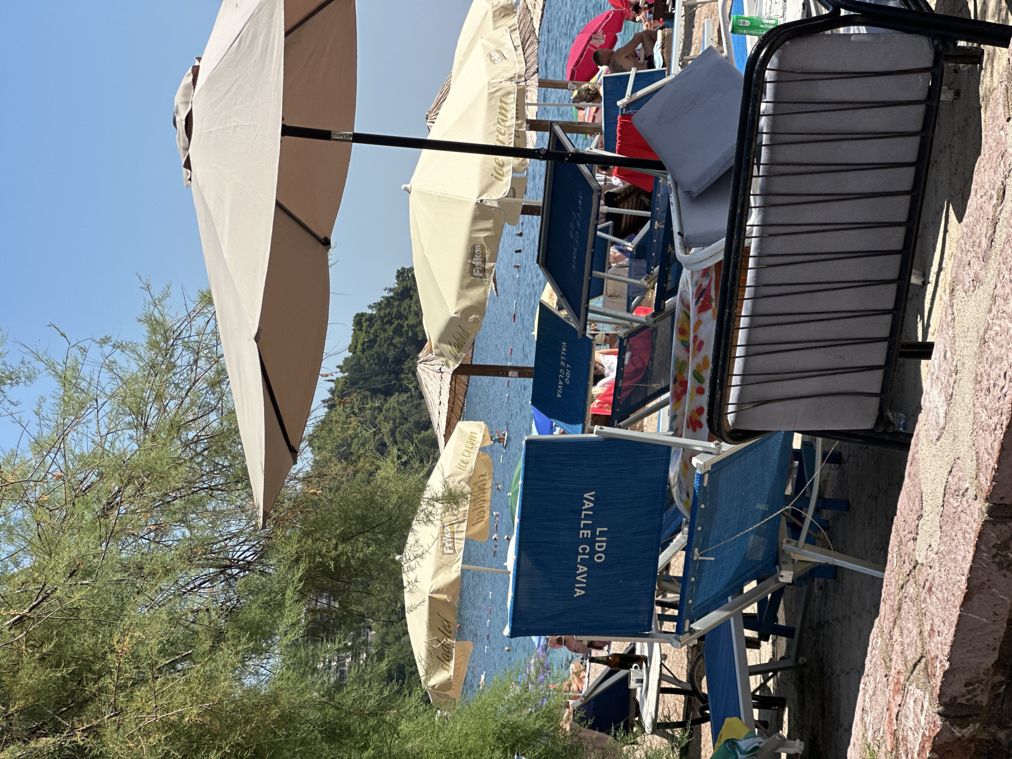 Budva beach in full summer mode — crowds, water toys, café