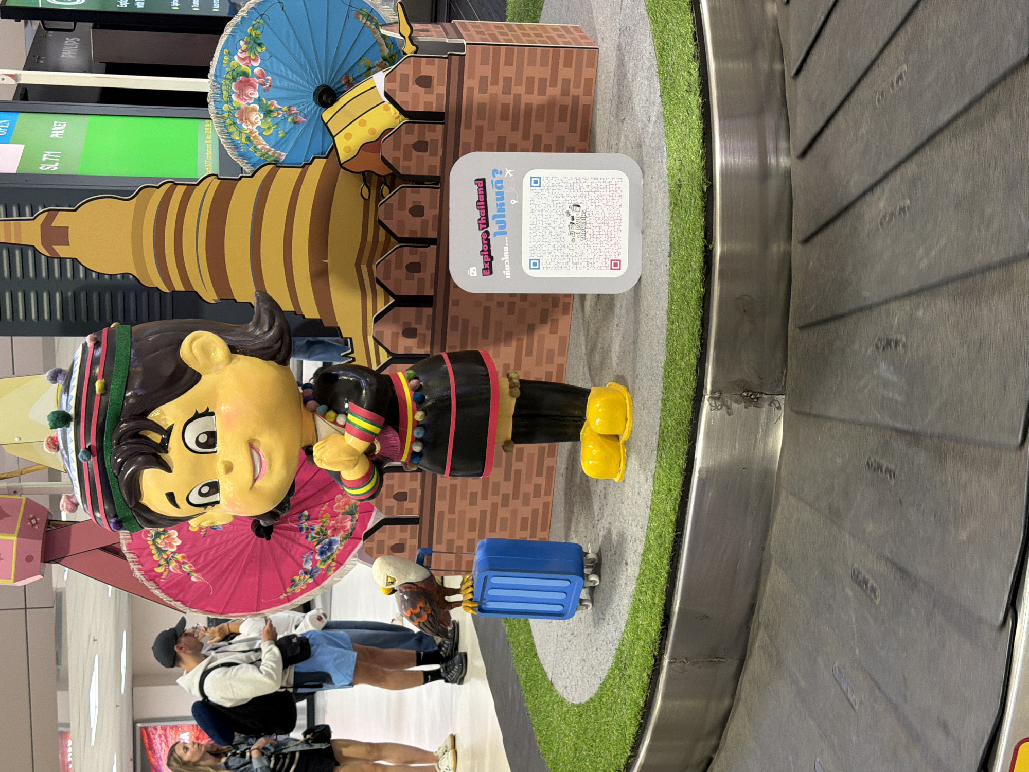 Bangkok airport baggage claim features traditional Thai cultural display