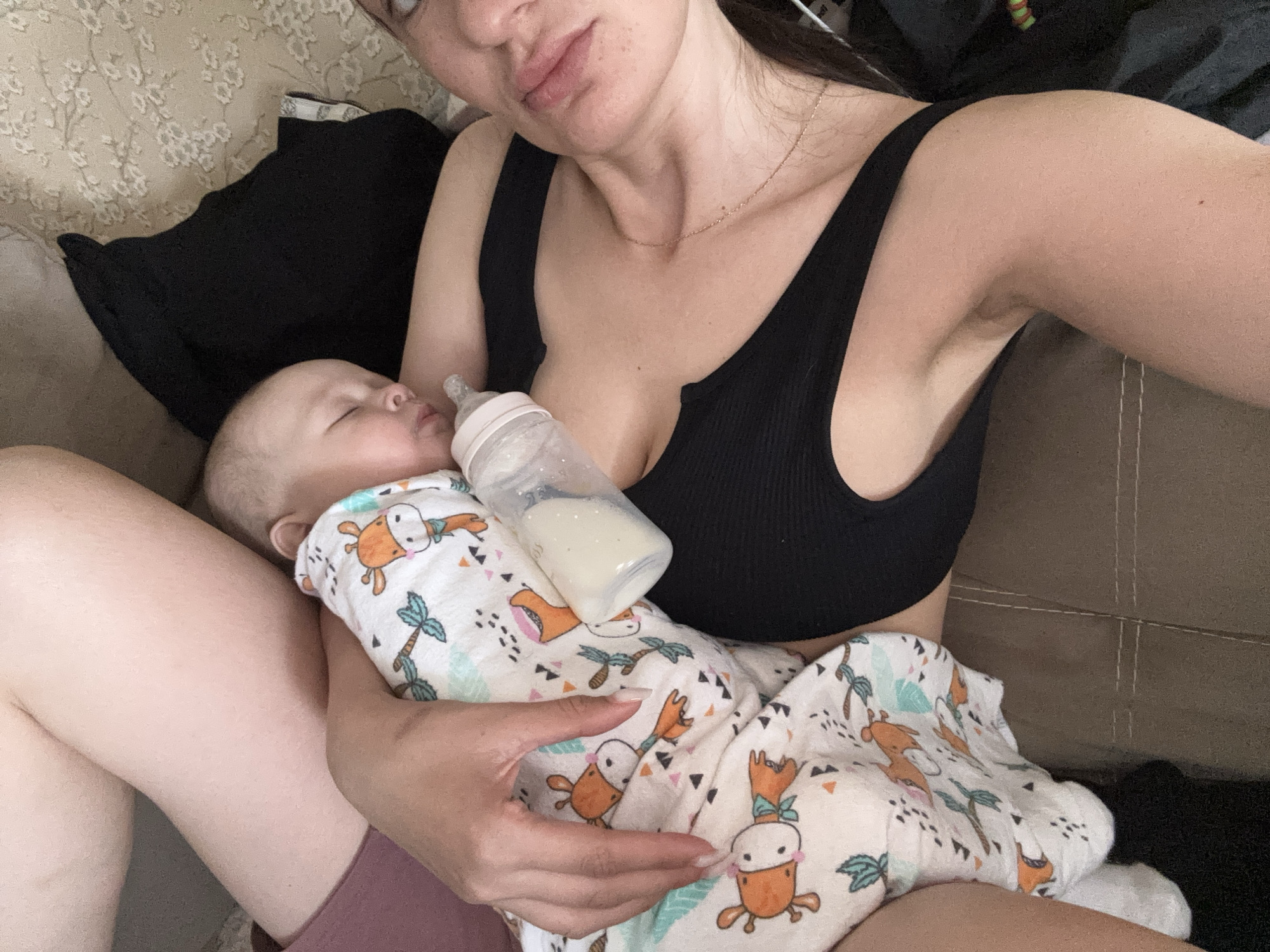 Mother feeds baby with bottle in early morning Sochi