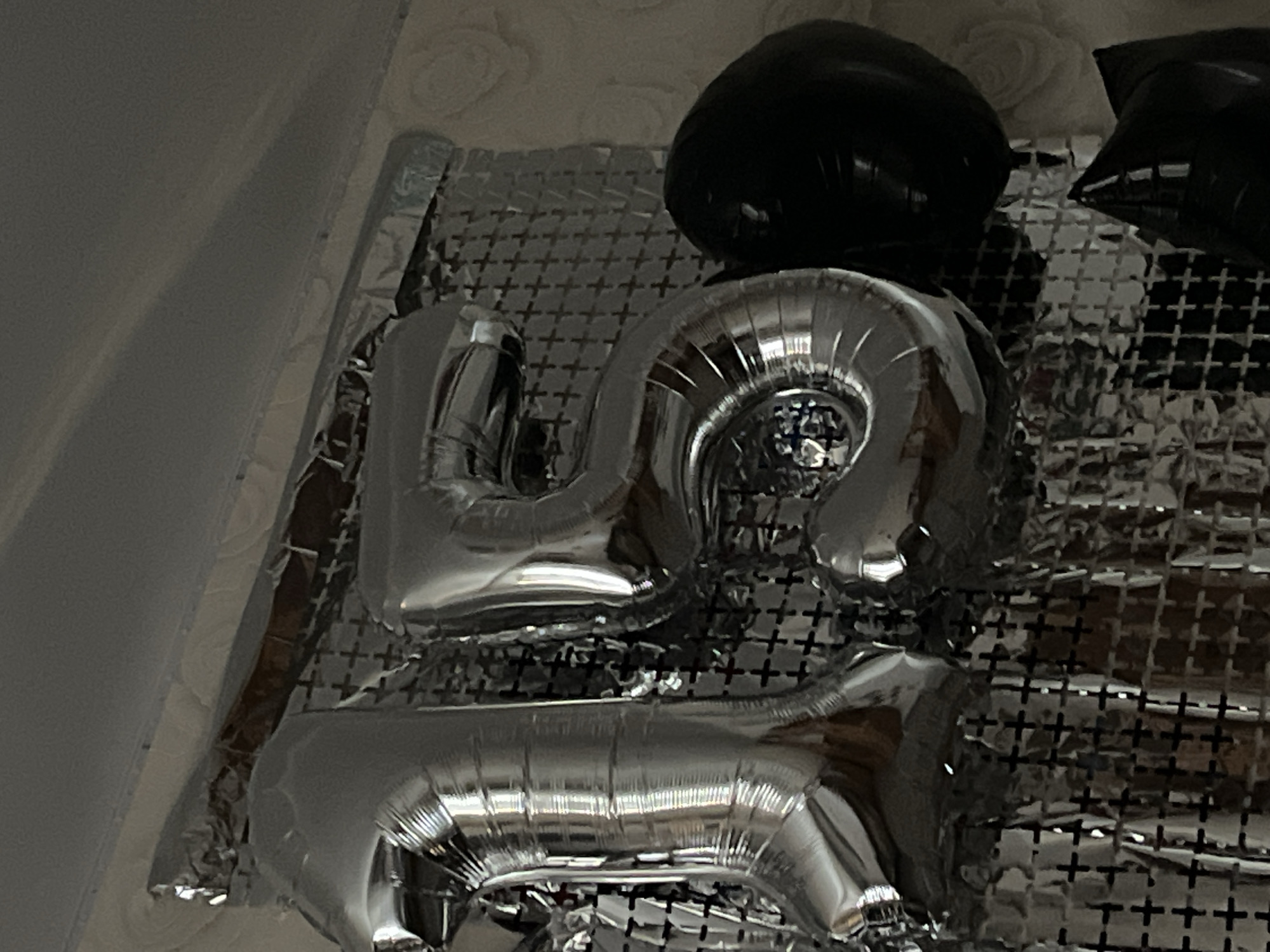 Silver '15' foil balloons against a crinkled metallic backdrop