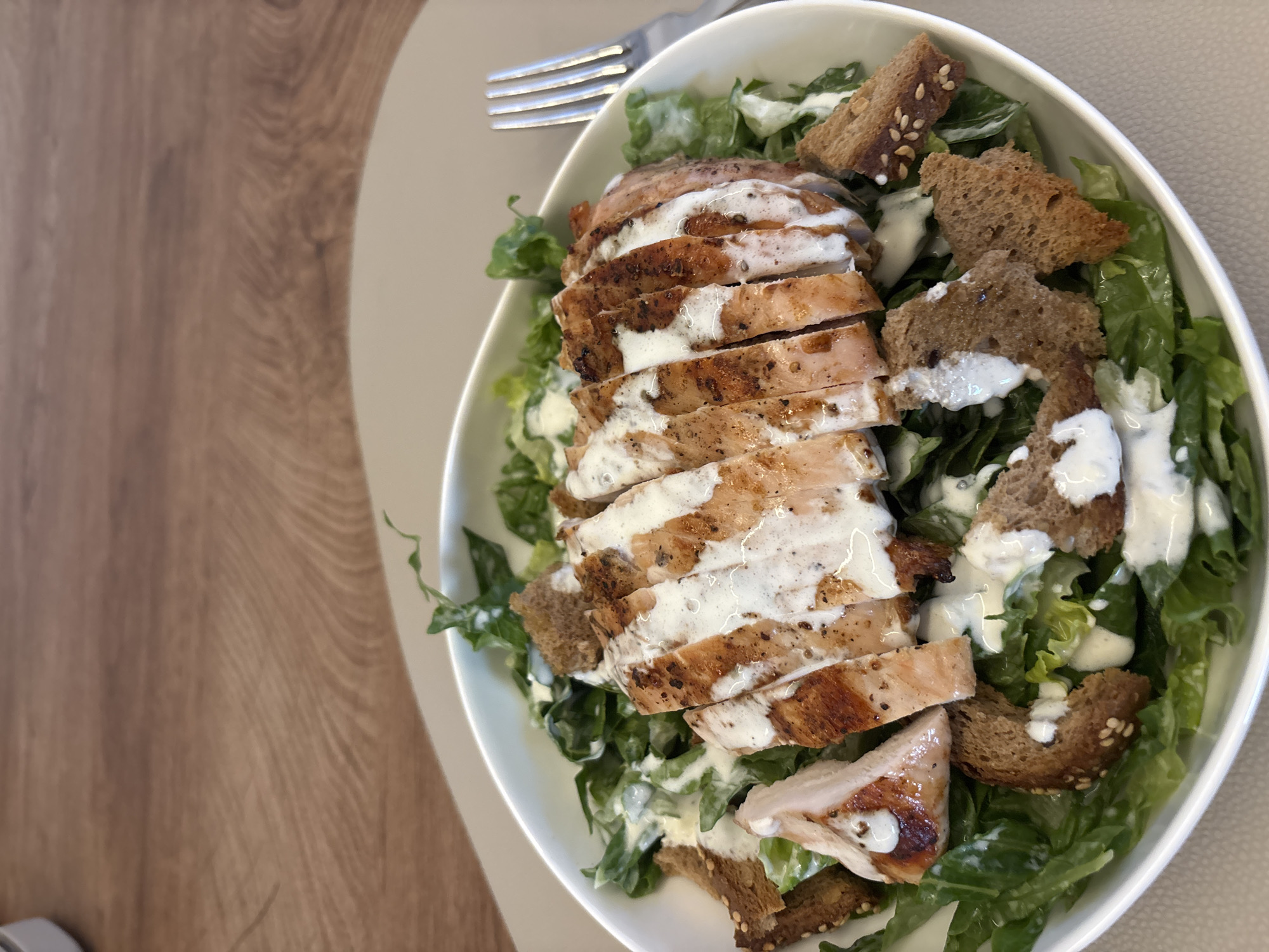 Chicken Caesar salads on a wooden table in Viernheim