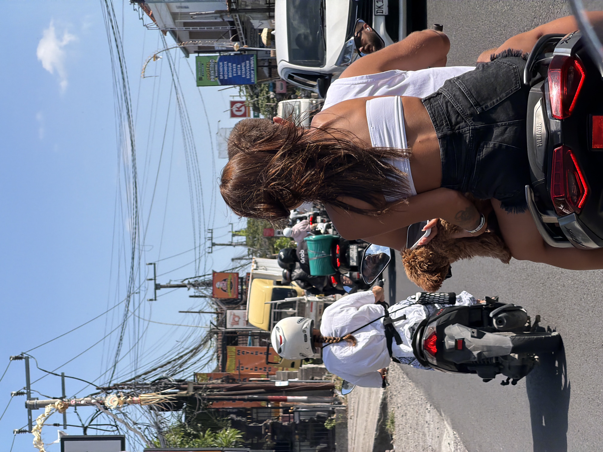 Scooter and overloaded garbage truck on Mengwi streets