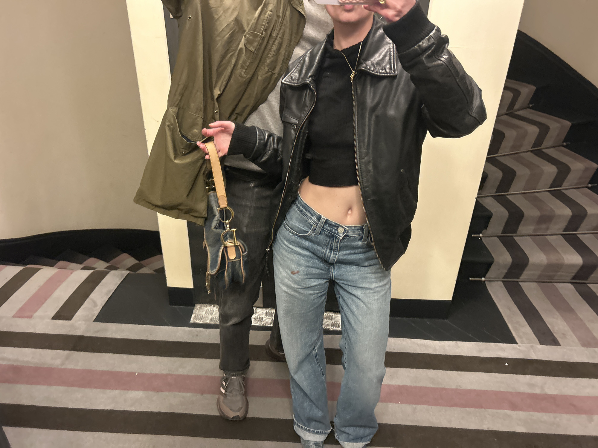 Person poses for photo in hallway wearing casual outfit