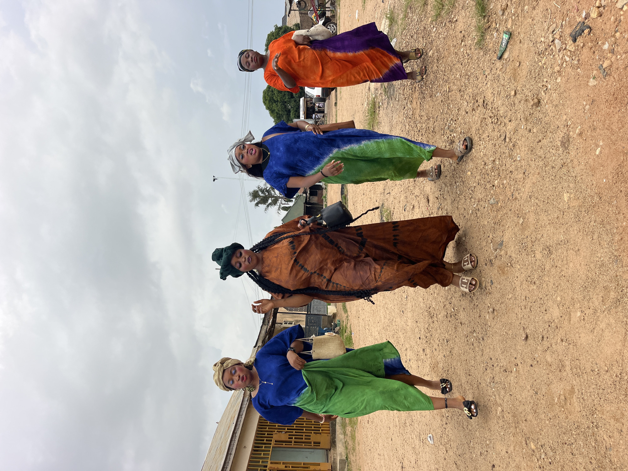 Women in traditional dress gather on rural roads