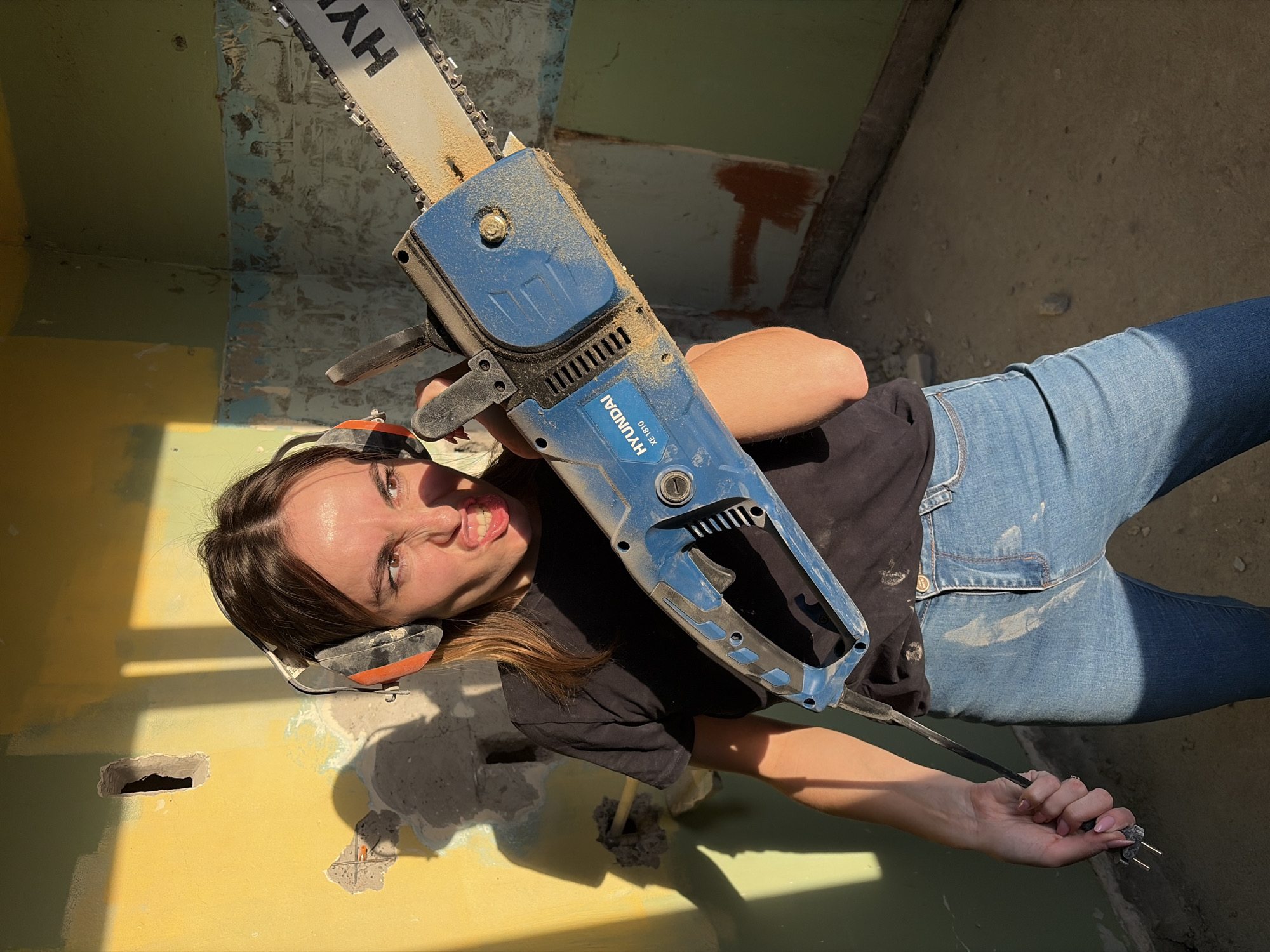 Woman operates chainsaw during home renovation in Izhevsk