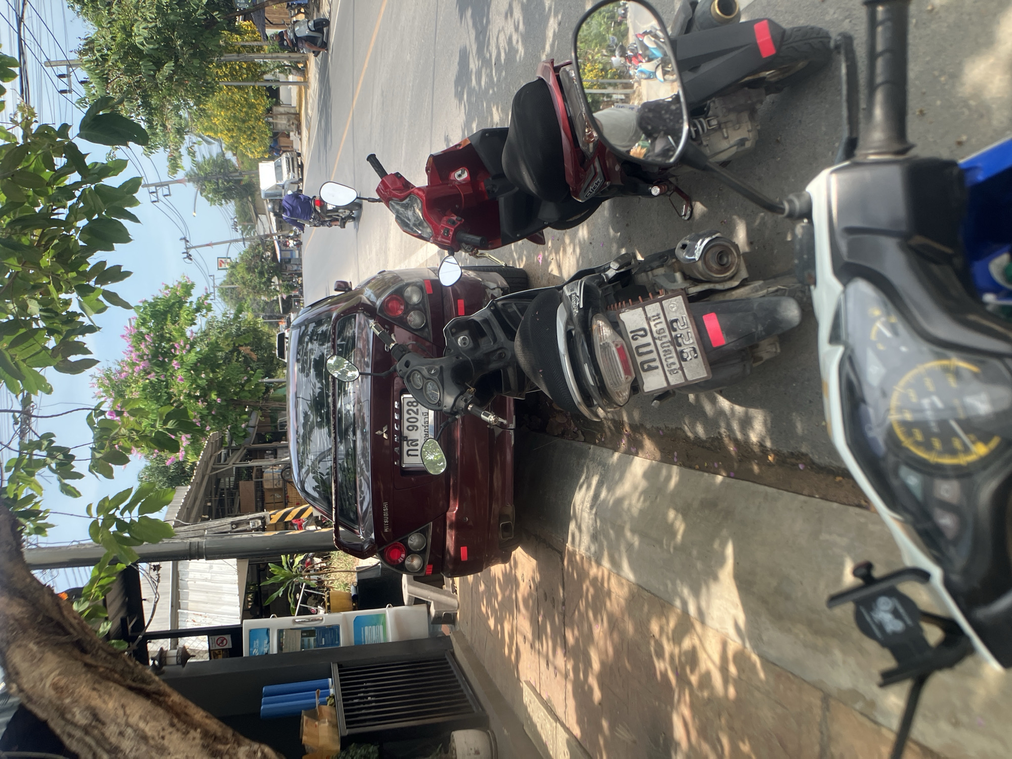 Vehicles parked on street in Baan Plai Laem, Thailand