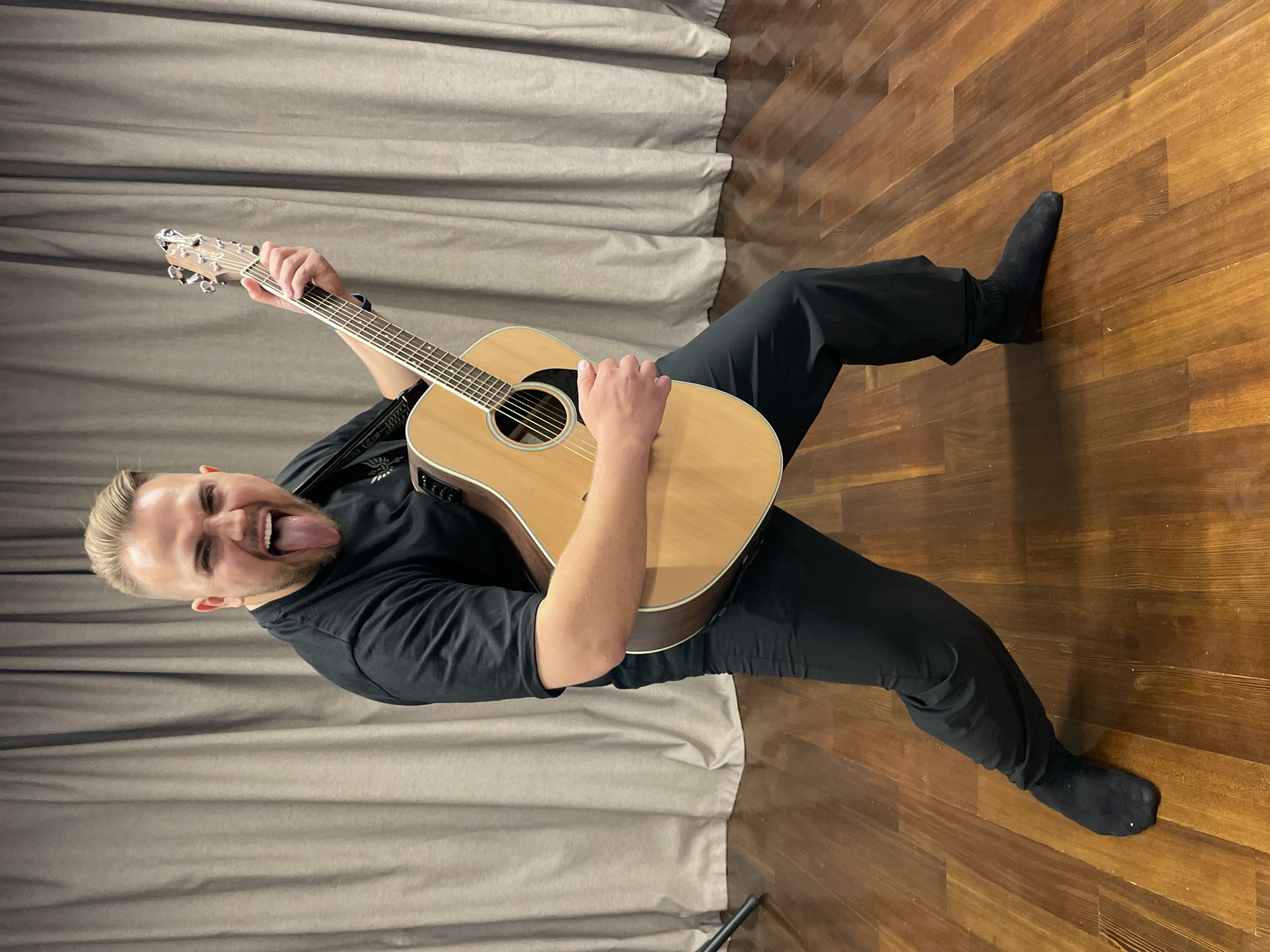 Guitarist poses playfully with acoustic guitar in Moscow