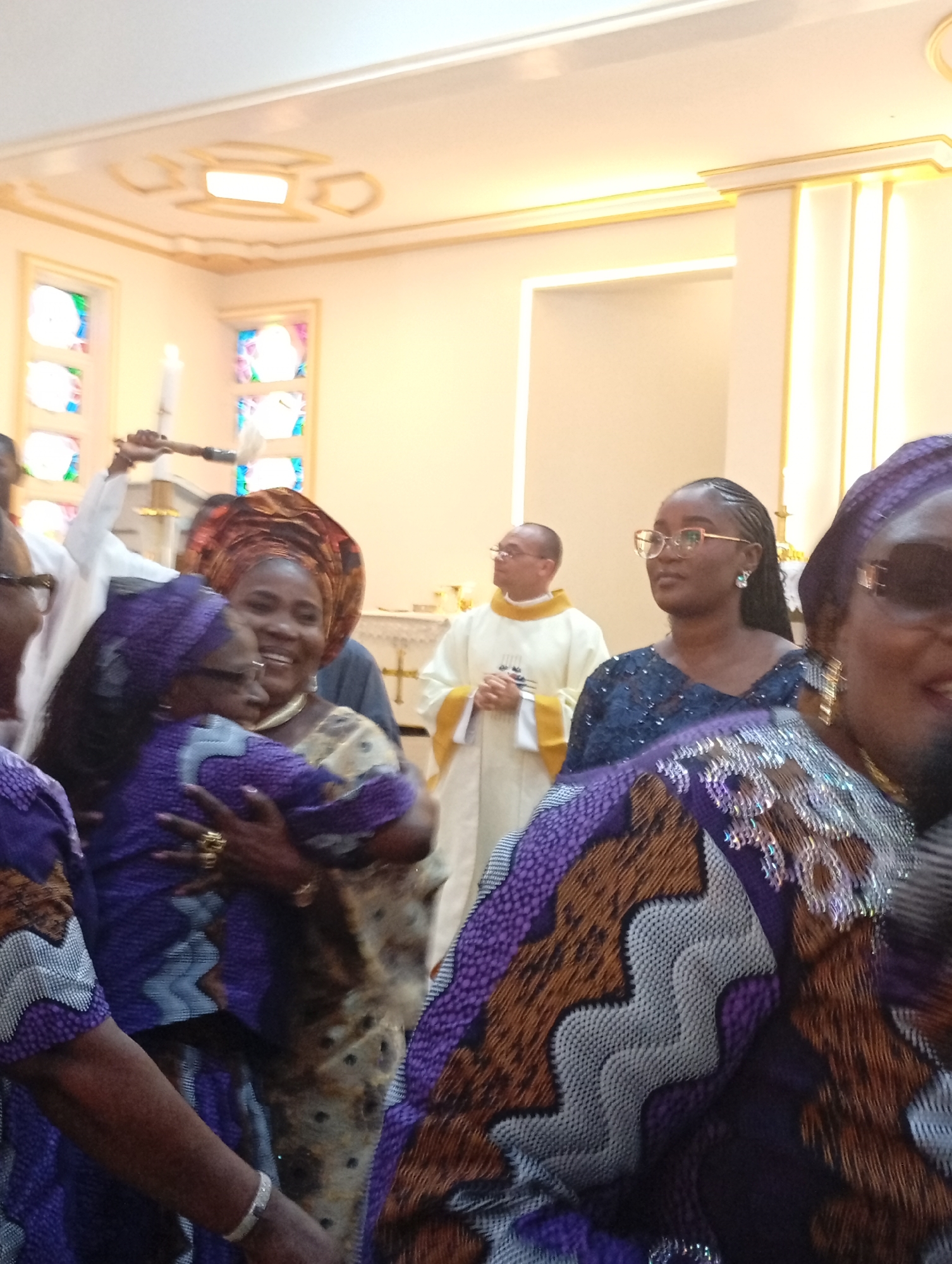 Religious service observed with traditionally dressed congregants and priest