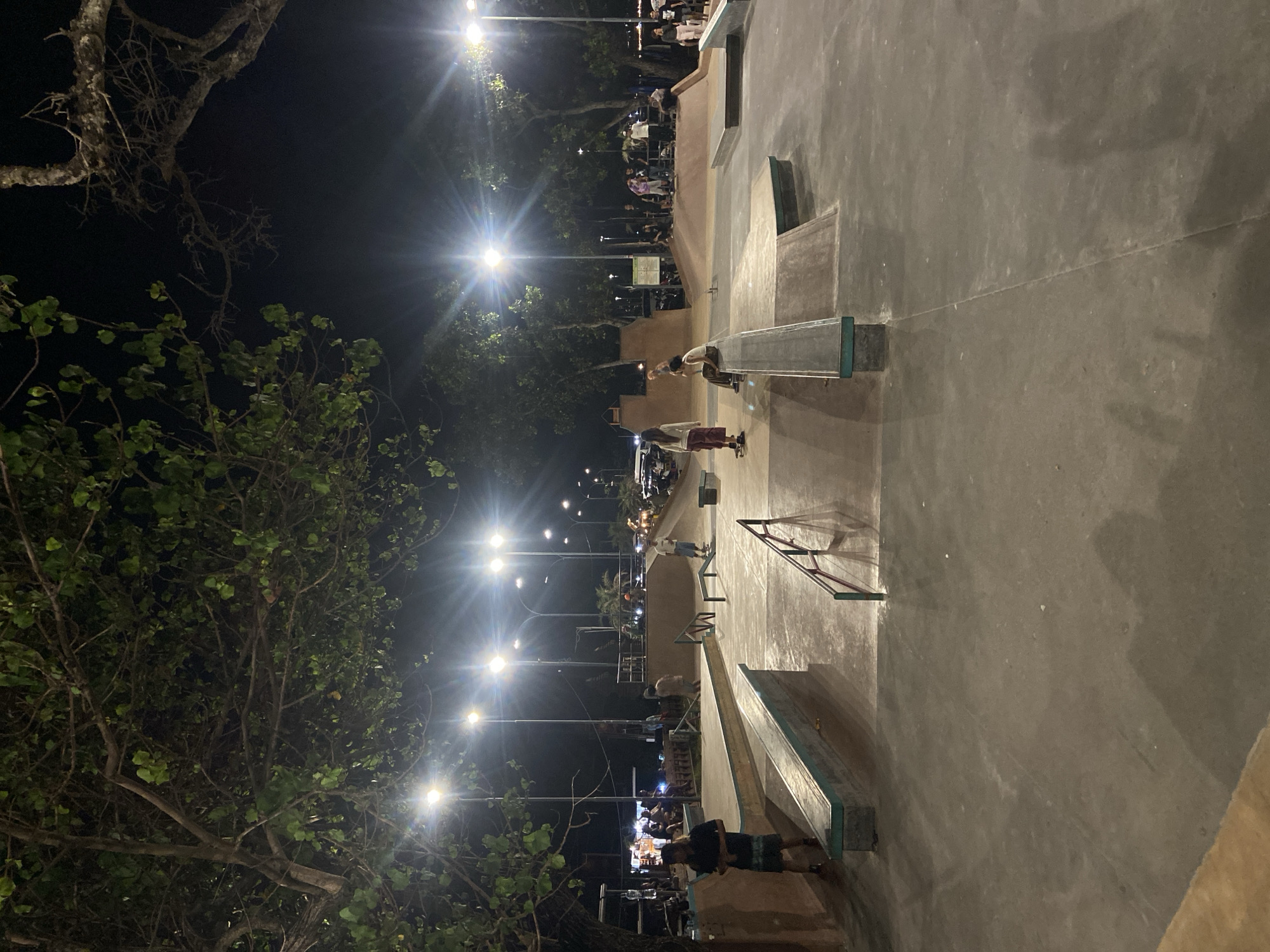 Nighttime street life and skateboarding activity observed in Kuta