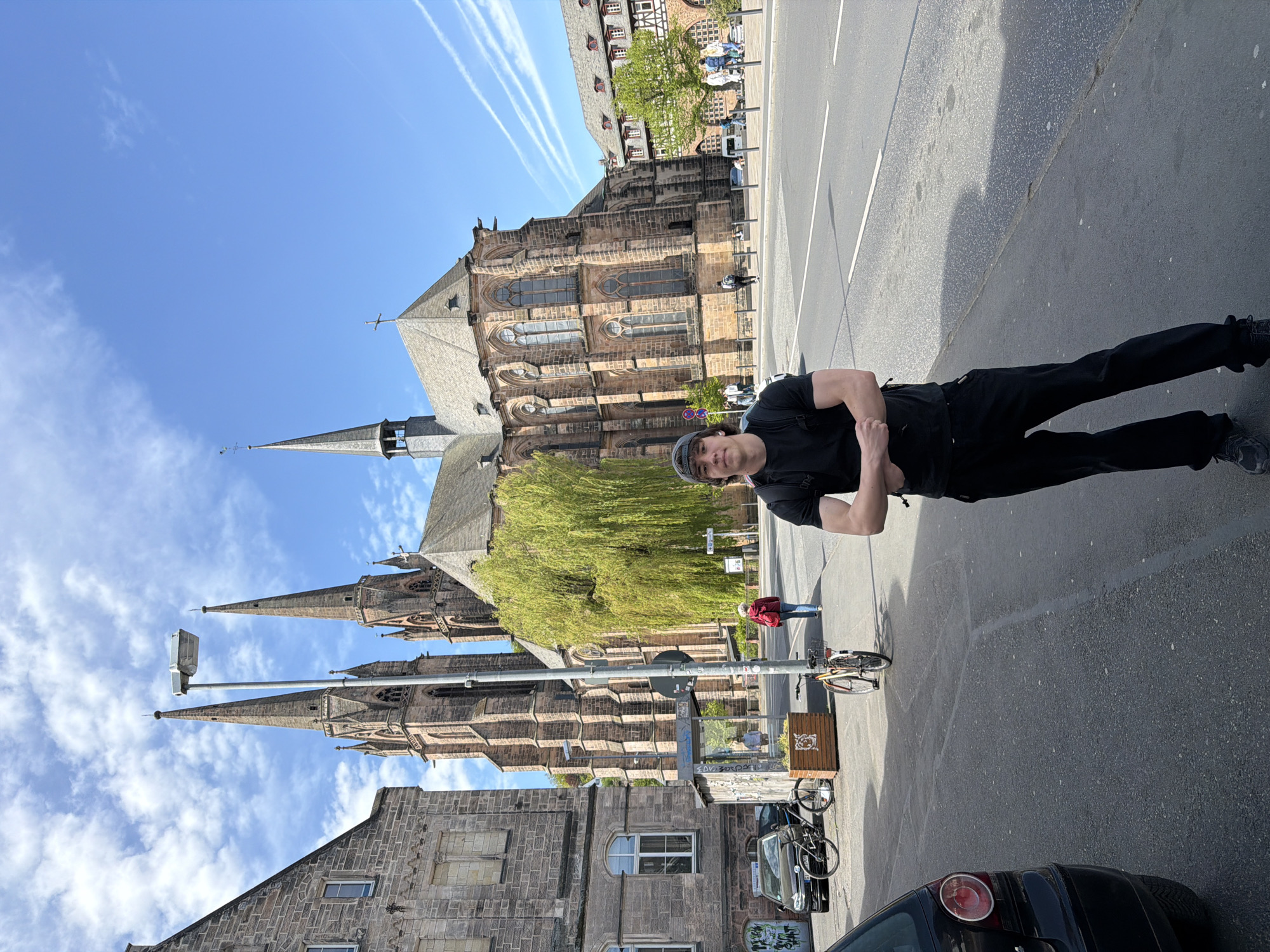 Man photographed on sunny street near gothic church in Marburg