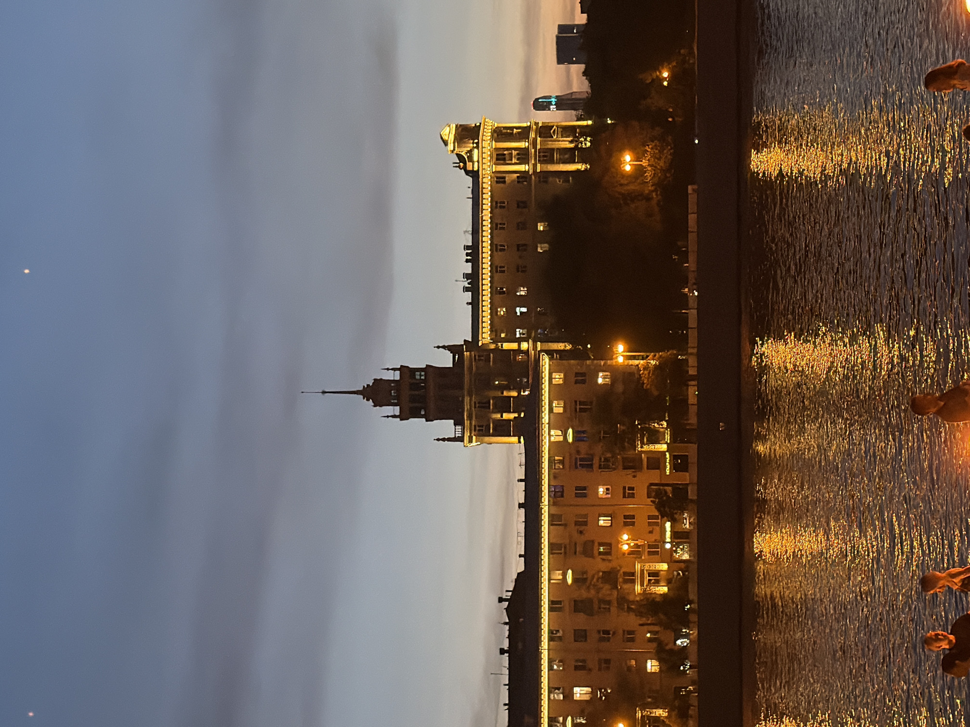 Moscow River at dusk: city lights, riverside deck, people dancing