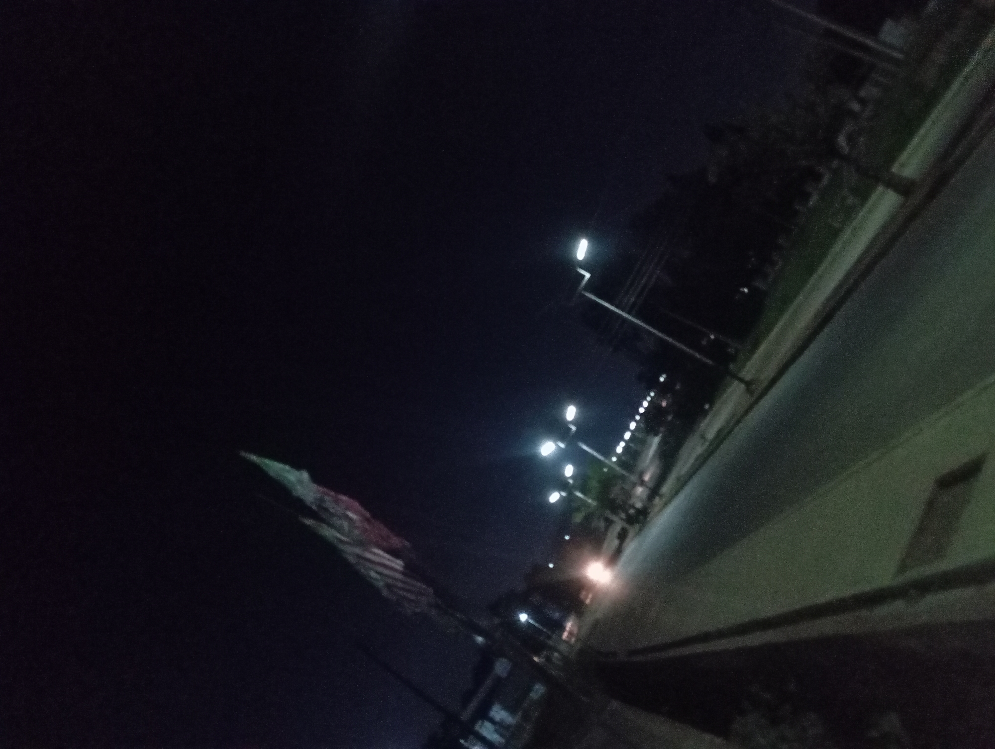 Night on a Nigerian commercial street, storefronts and streetlights