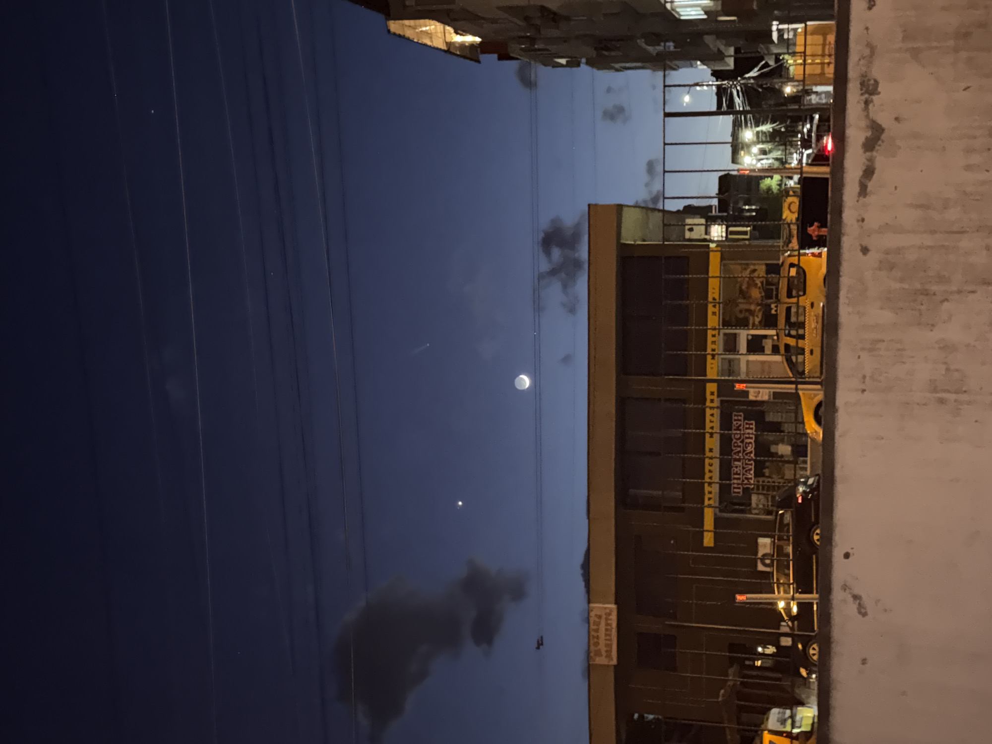 Crescent moon observed over illuminated buildings in Burgas, Bulgaria