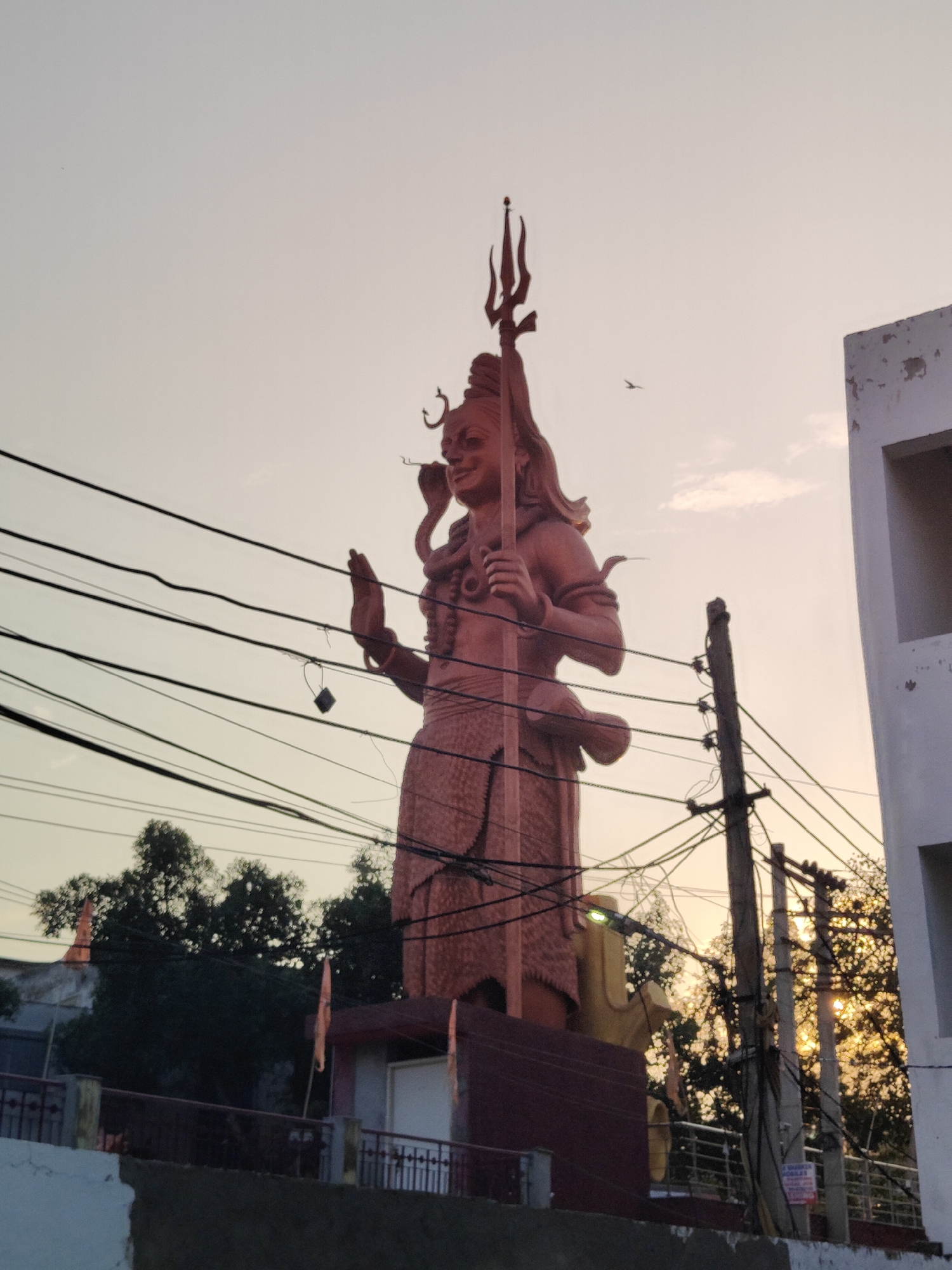 Shiva shrine in Gurgaon at golden hour, offerings and statues