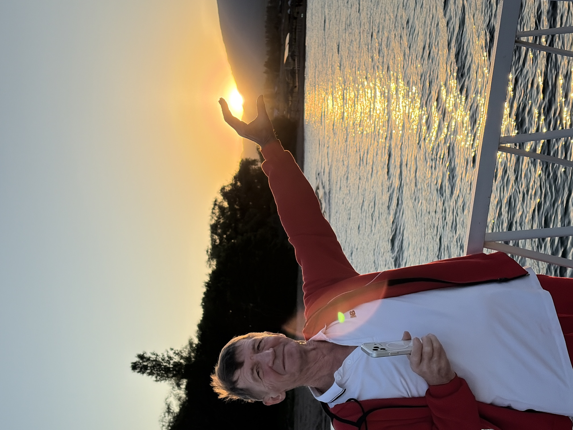Afternoon at a scenic waterfront with mountains, flowers, and sunset views