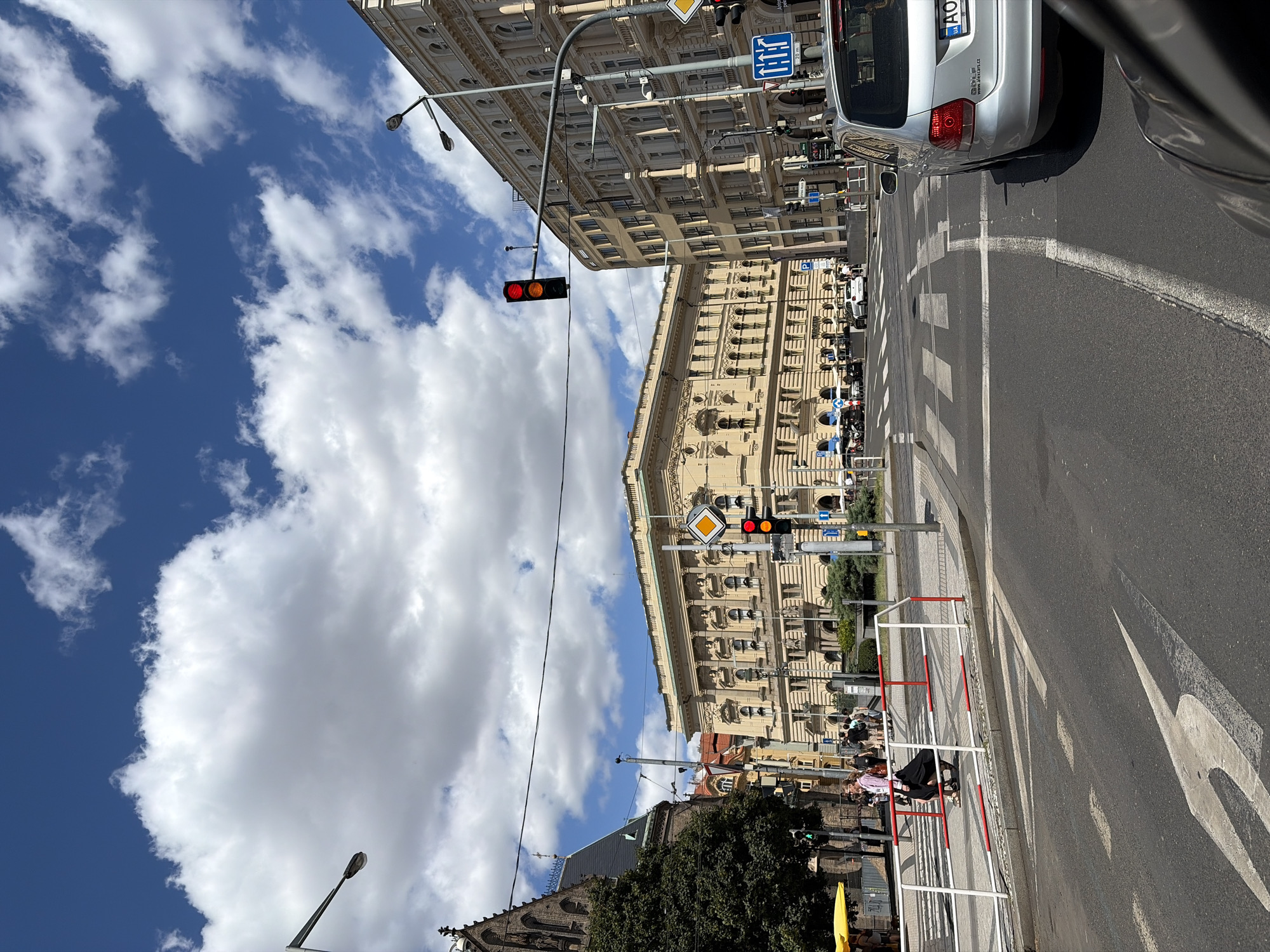 Sunny afternoon at a Prague street corner near a brick church