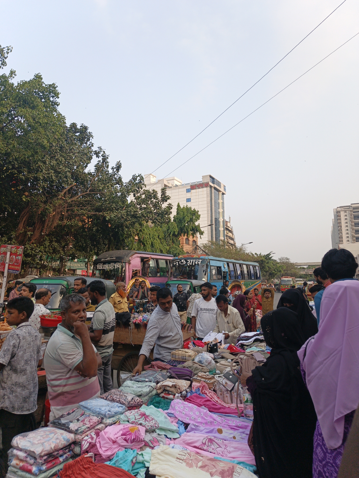 Street vendors operate busy market stalls in Dhaka