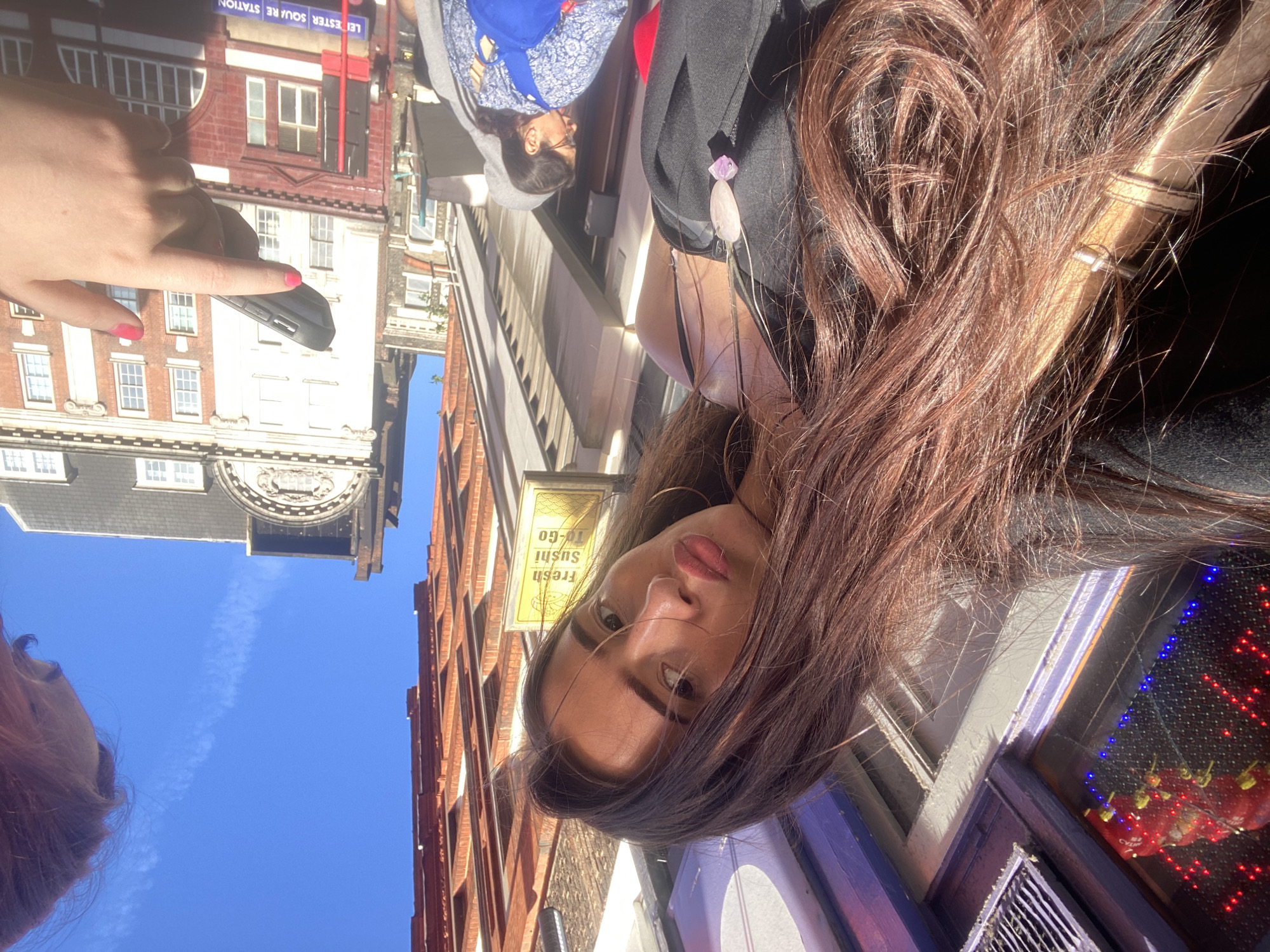 Woman takes selfie near sushi shop in London Chinatown