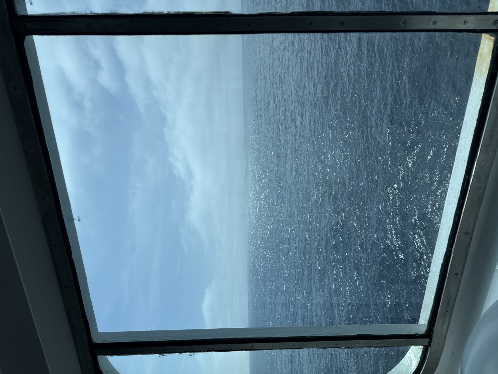 Window view captures sky and ocean scene