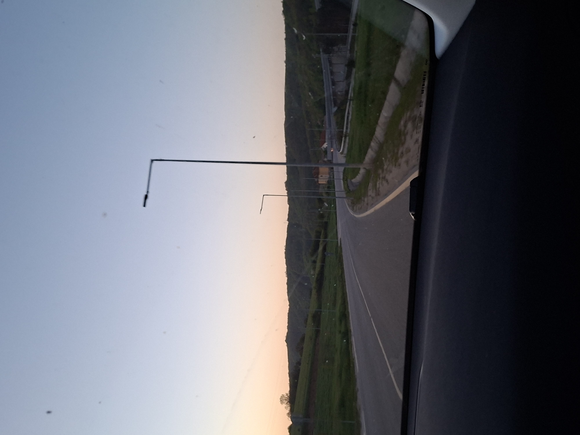 Vehicle travels illuminated road during twilight in Gabrovo, Bulgaria