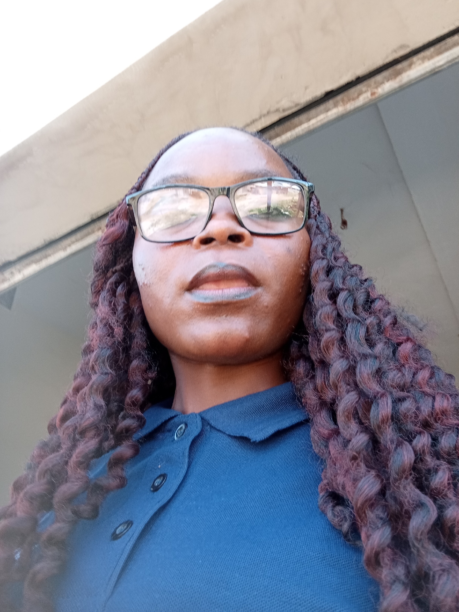 Series of portraits in Jalingo, Nigeria — navy polo, braids, glasses.