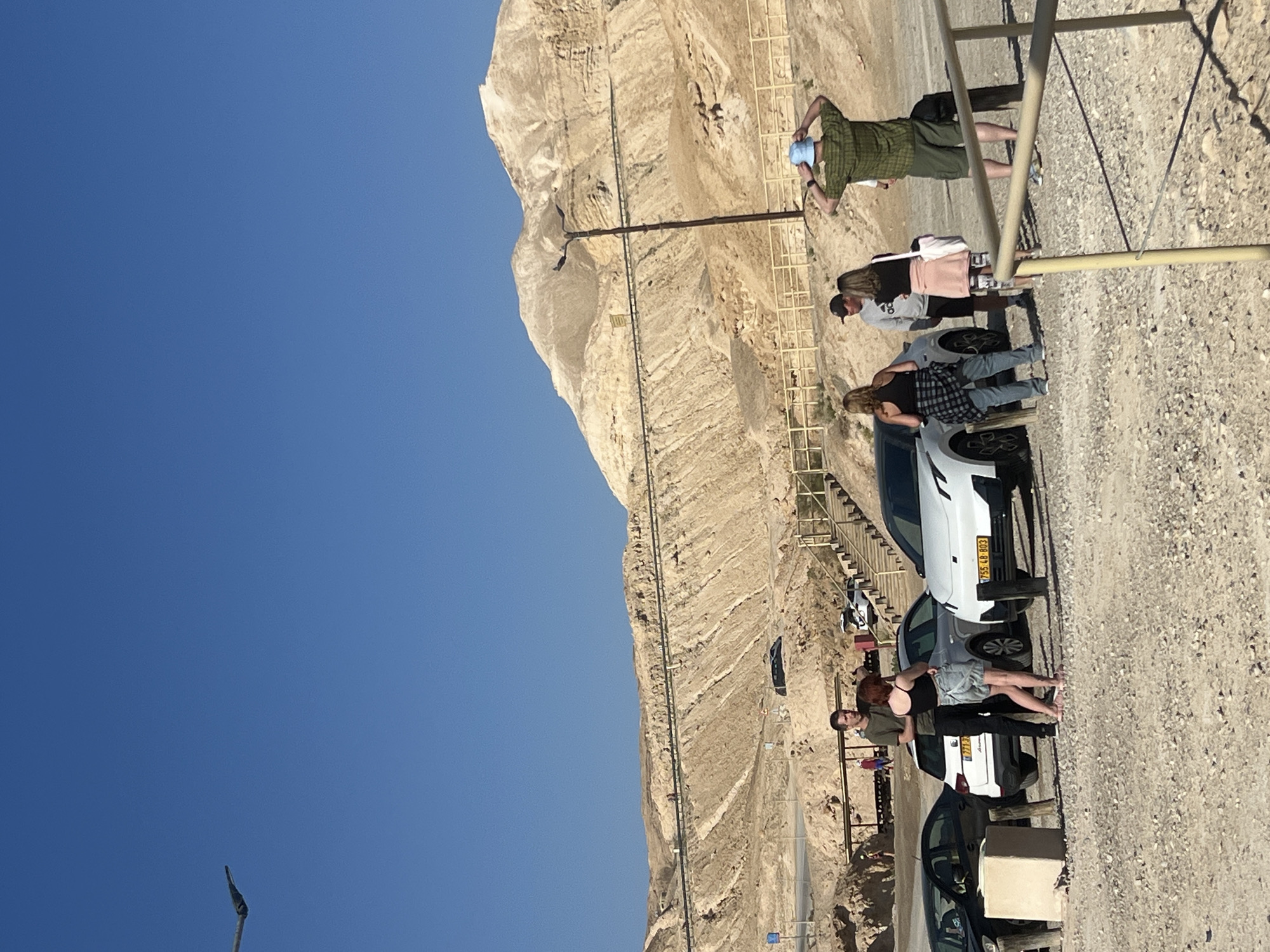 Early morning hikers gather on rocky mountainside in Israel