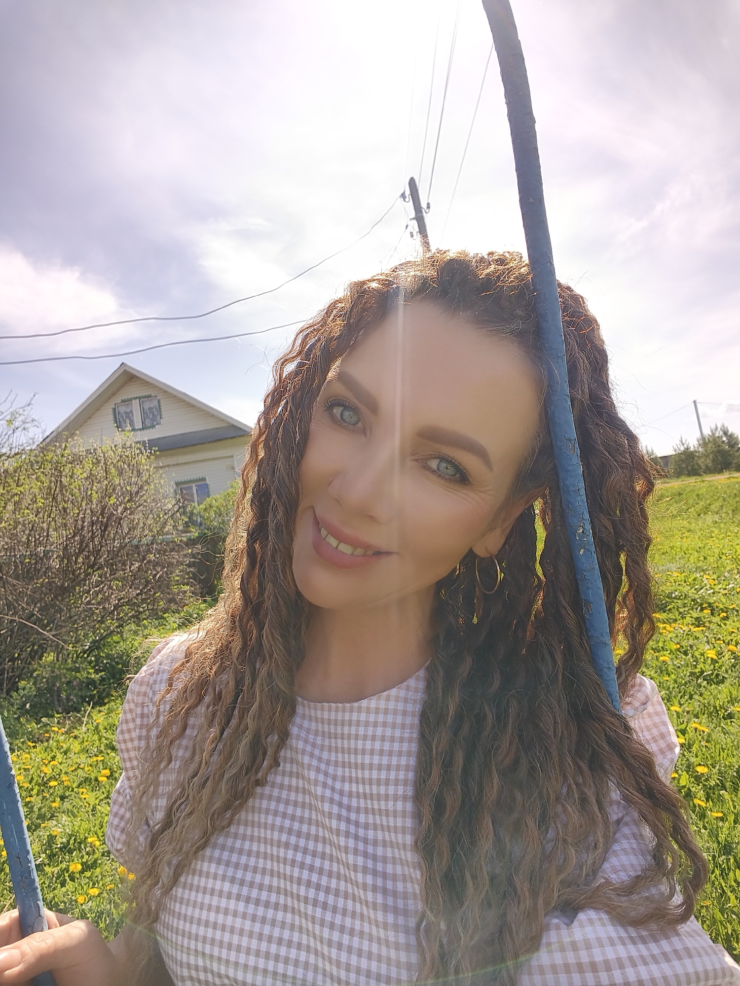 Woman in checkered dress documents dandelion picking and rural moments