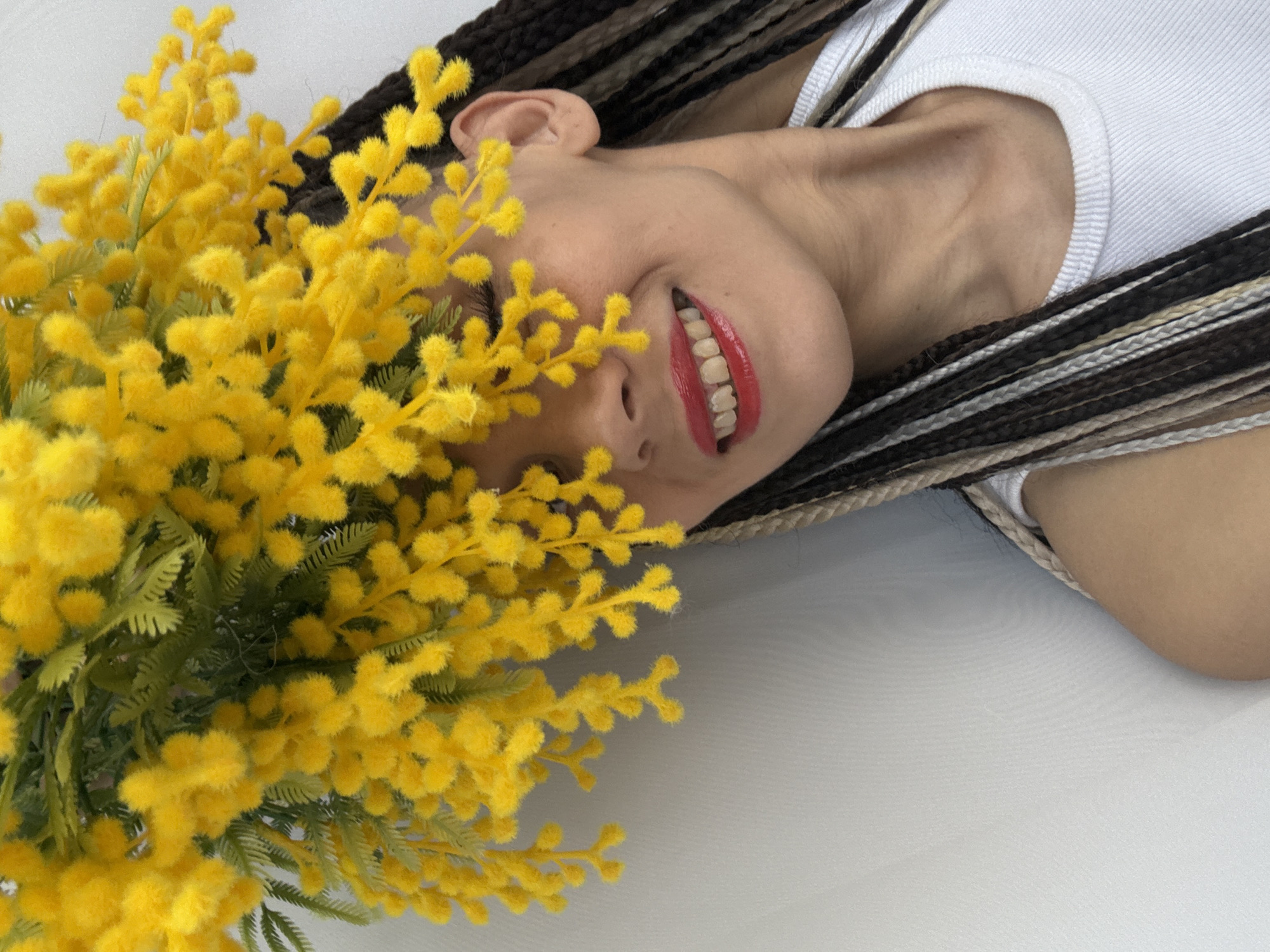 Person poses with yellow mimosa flowers in portrait session
