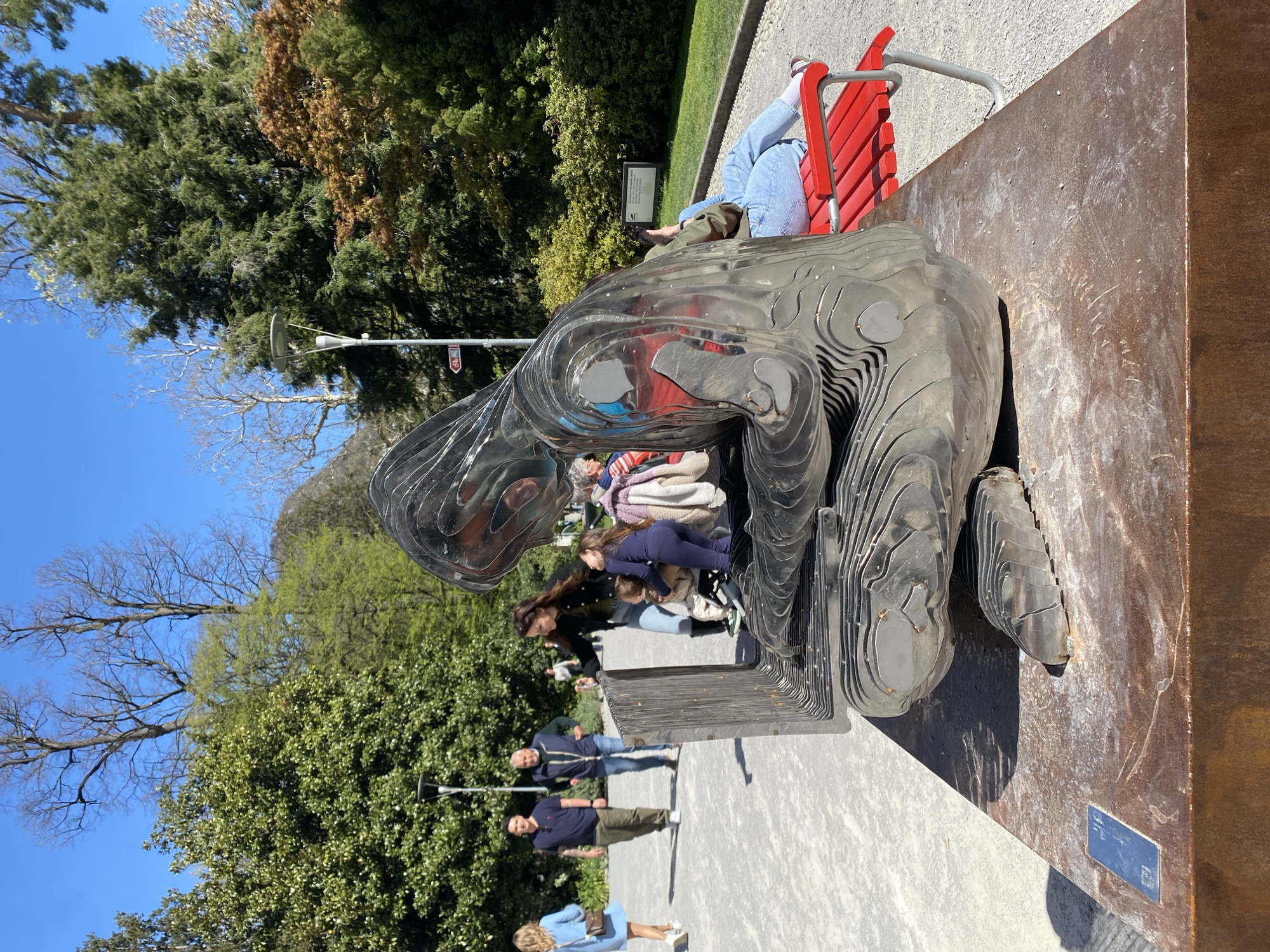 Toddler plays on public sculpture in Lugano lakeside park
