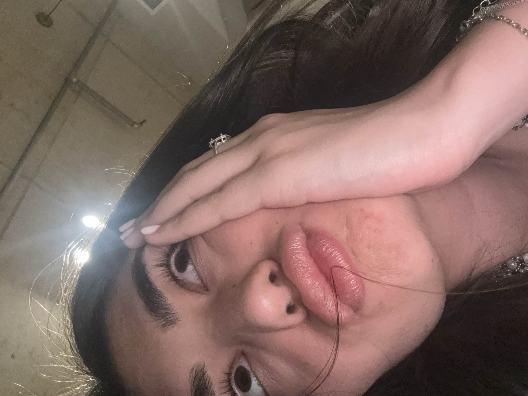 Person takes angled selfie with hand gesture in Milan