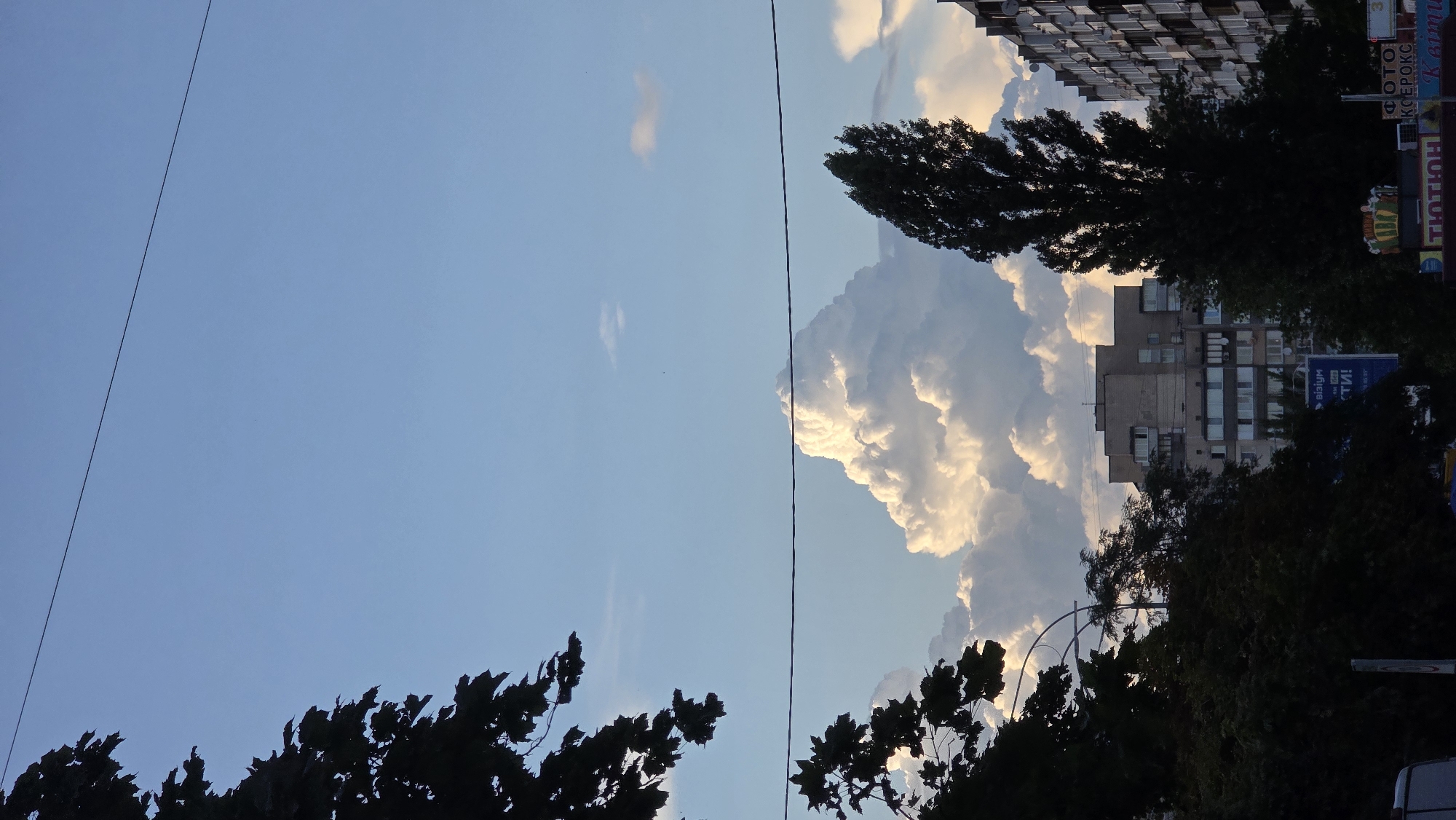 Kyiv skyline under a pale blue late-afternoon sky