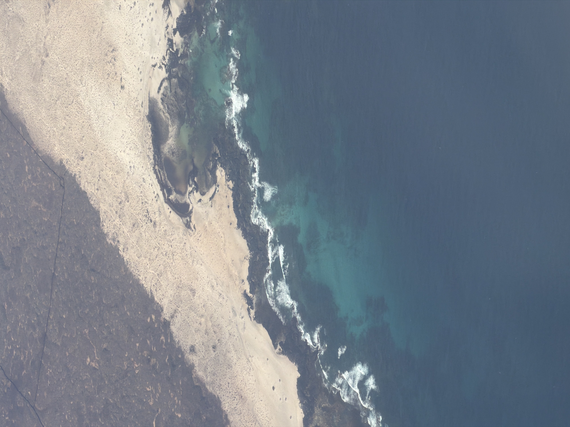 Coastal landscape captured showing terrain-to-beach transition in Los Lagos