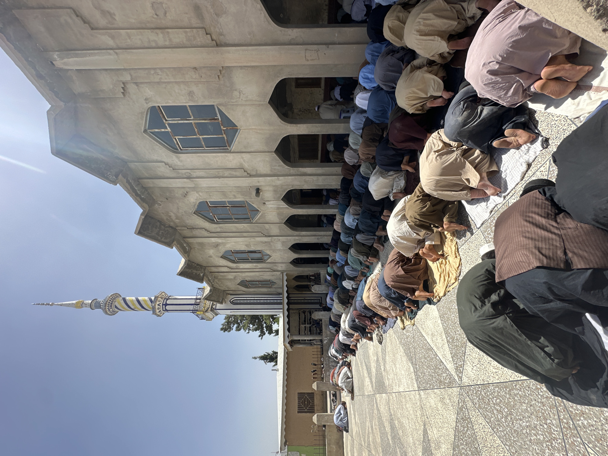 Men gather for communal prayer in mosque courtyard