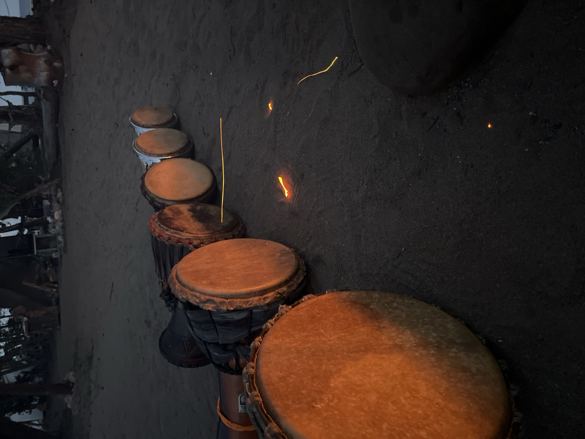 Drums, fire, and dusk at a casual beach gathering