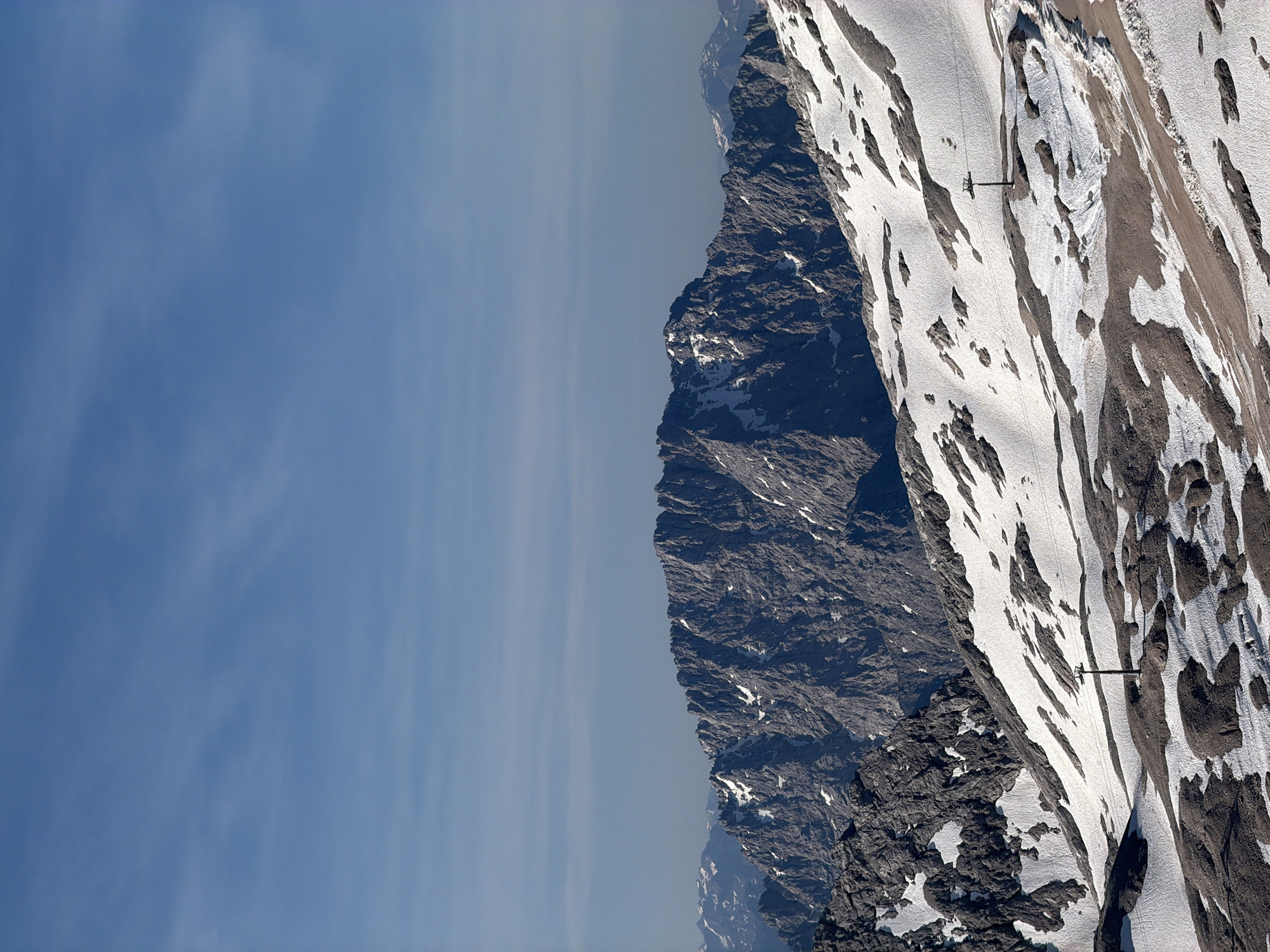 Snow-covered slopes and a ski lift pole in the Bavarian Alps.