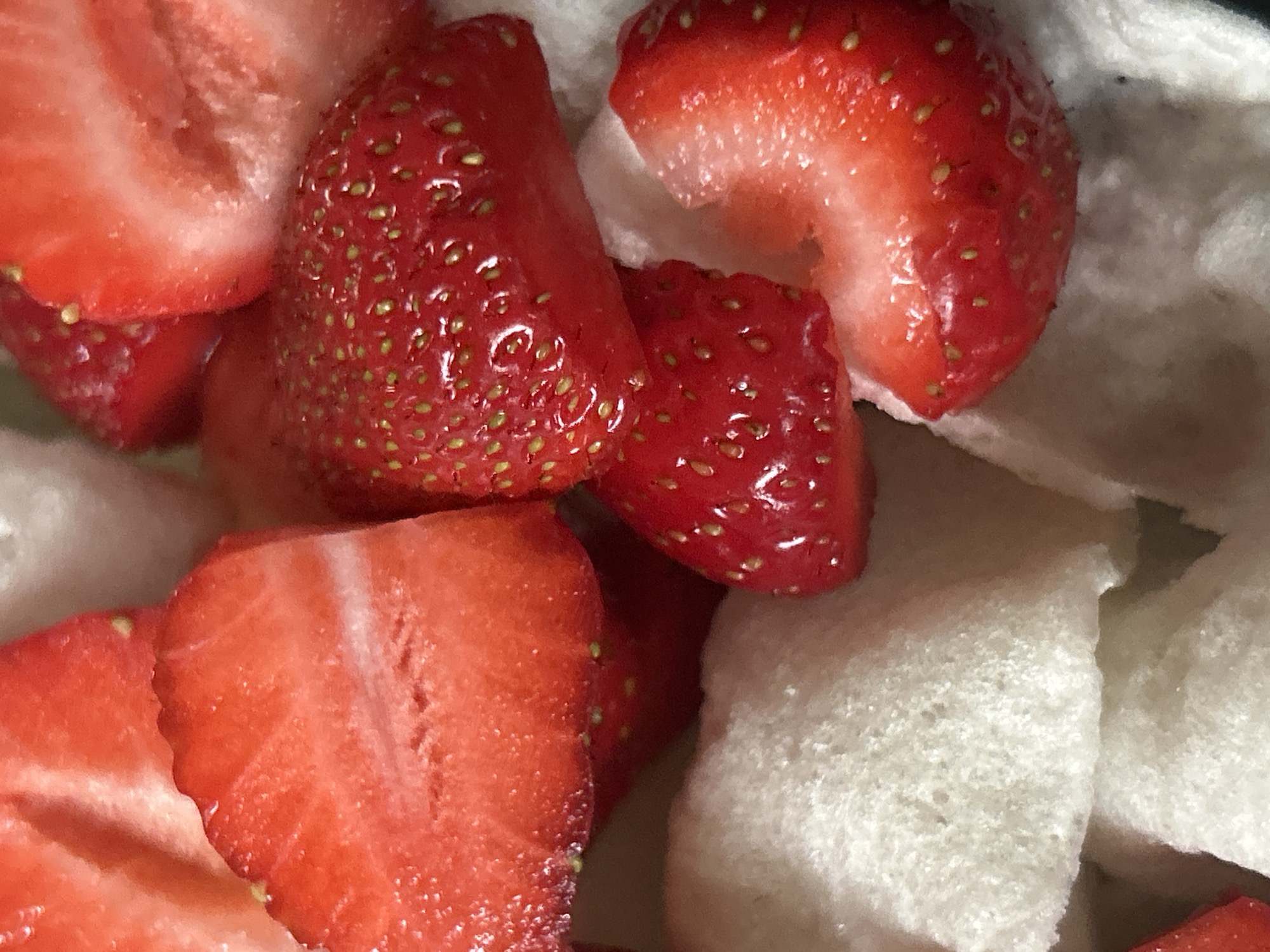 Strawberries and white crackers combined in black bowl snack