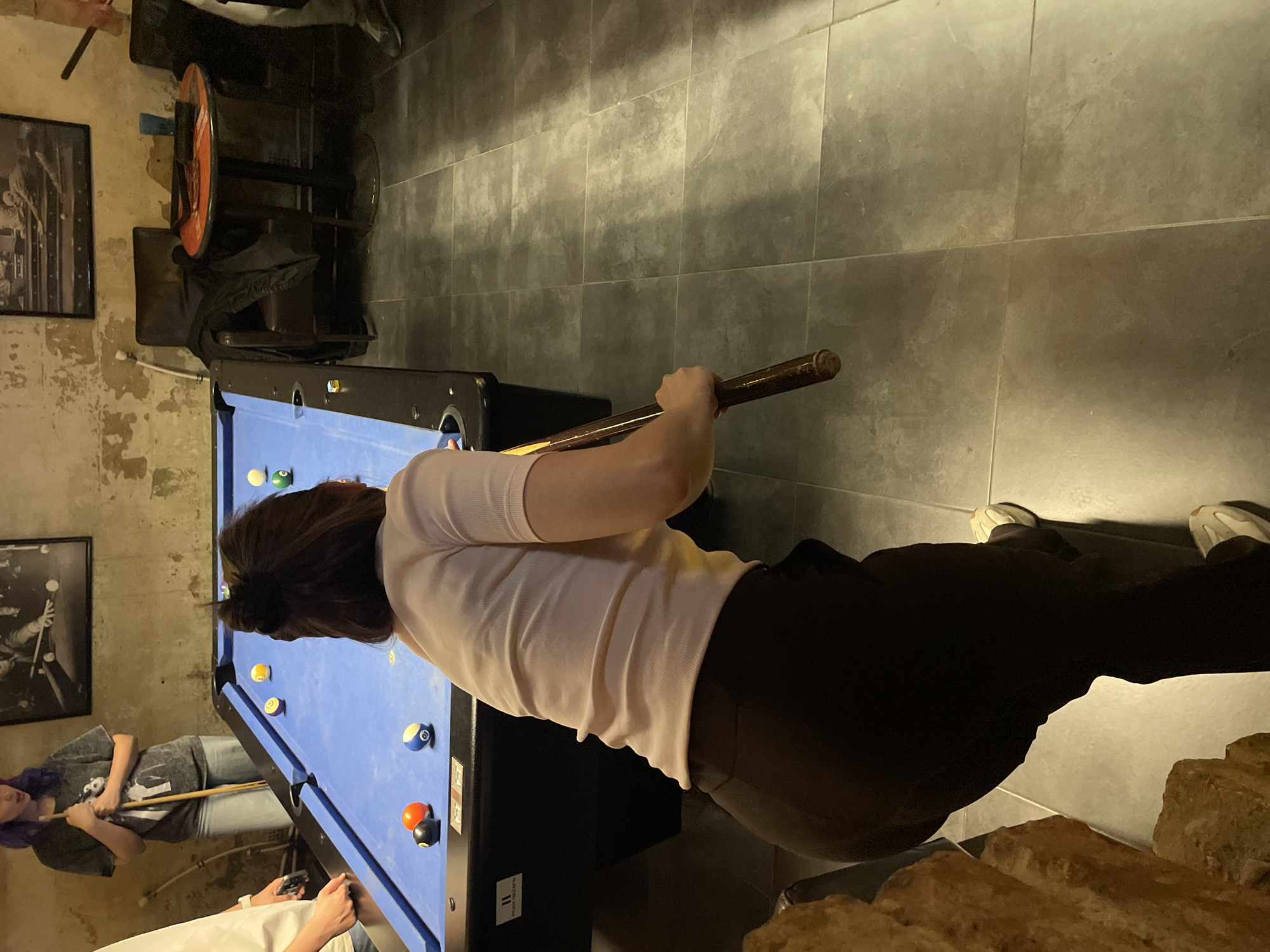 Woman plays pool in Budapest billiards room Friday evening
