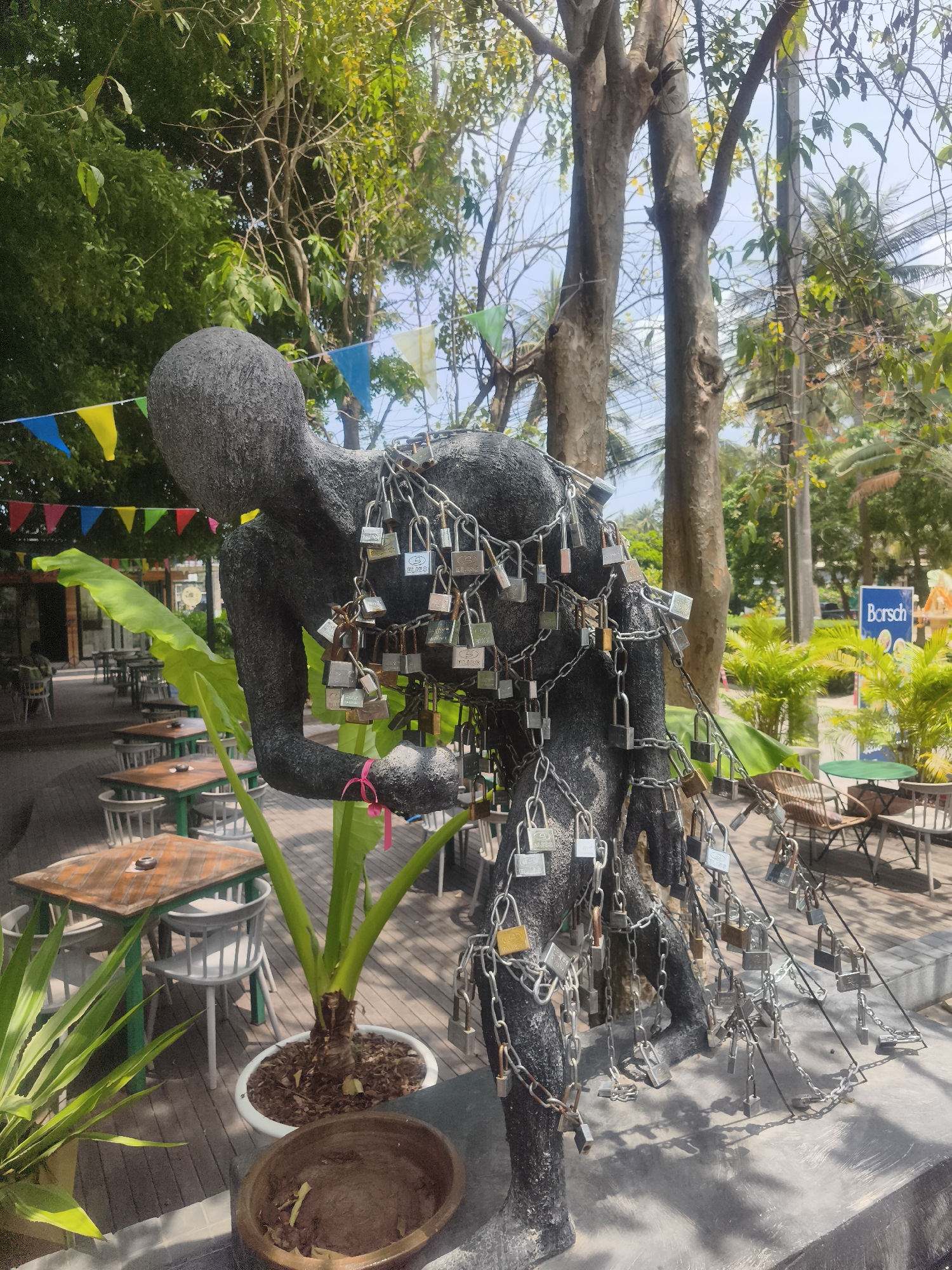 Chained sculpture observed in decorated outdoor dining area, Thailand