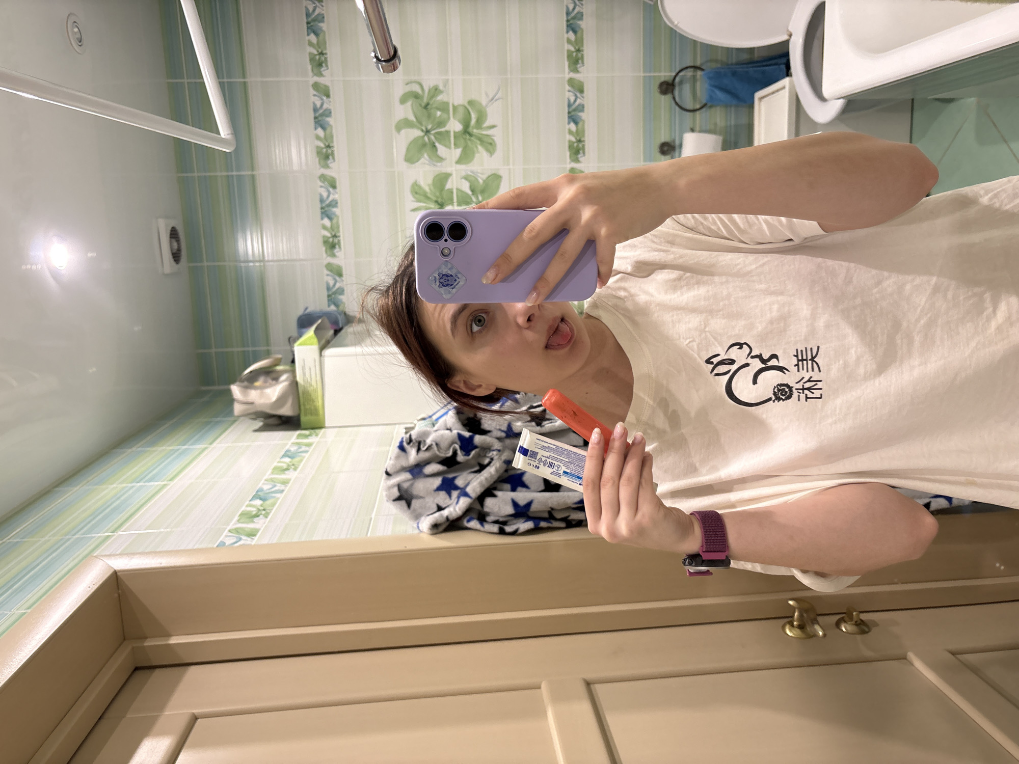 Person takes bathroom selfies with purple phone and lipstick