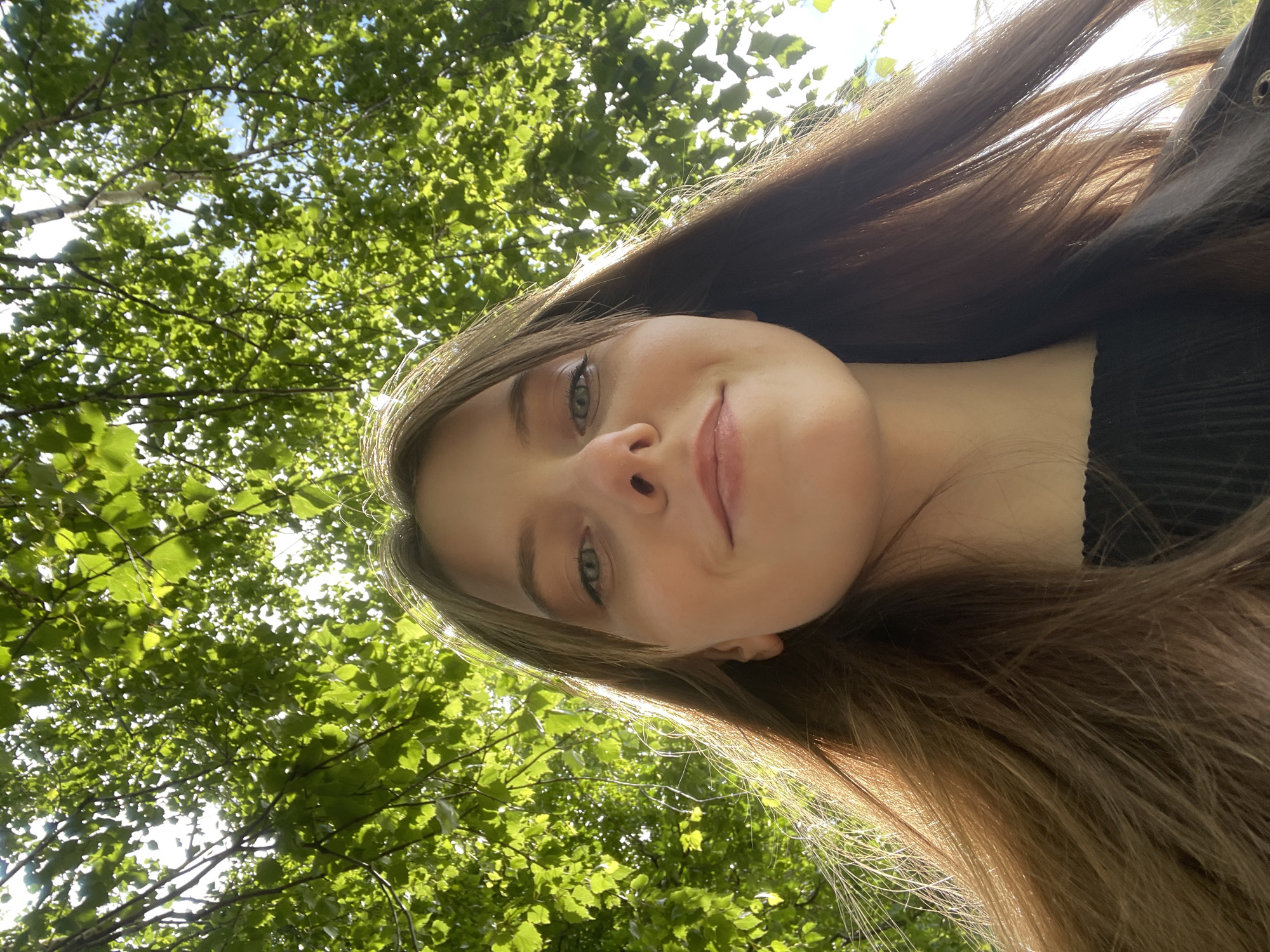 Young woman photographs herself near stone fence in Ufa