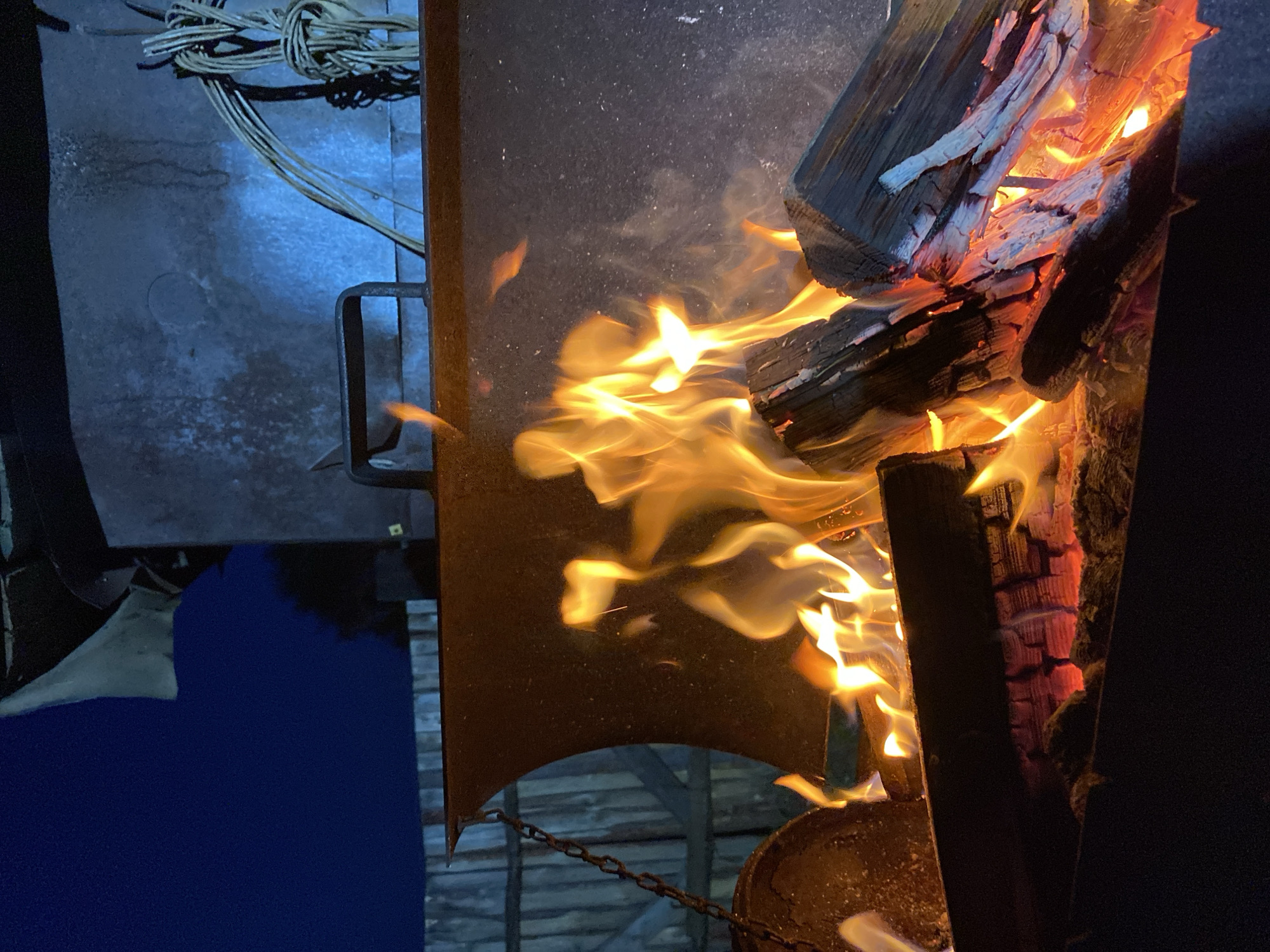 Woman documents evening outdoor activities around fire pit in Russia