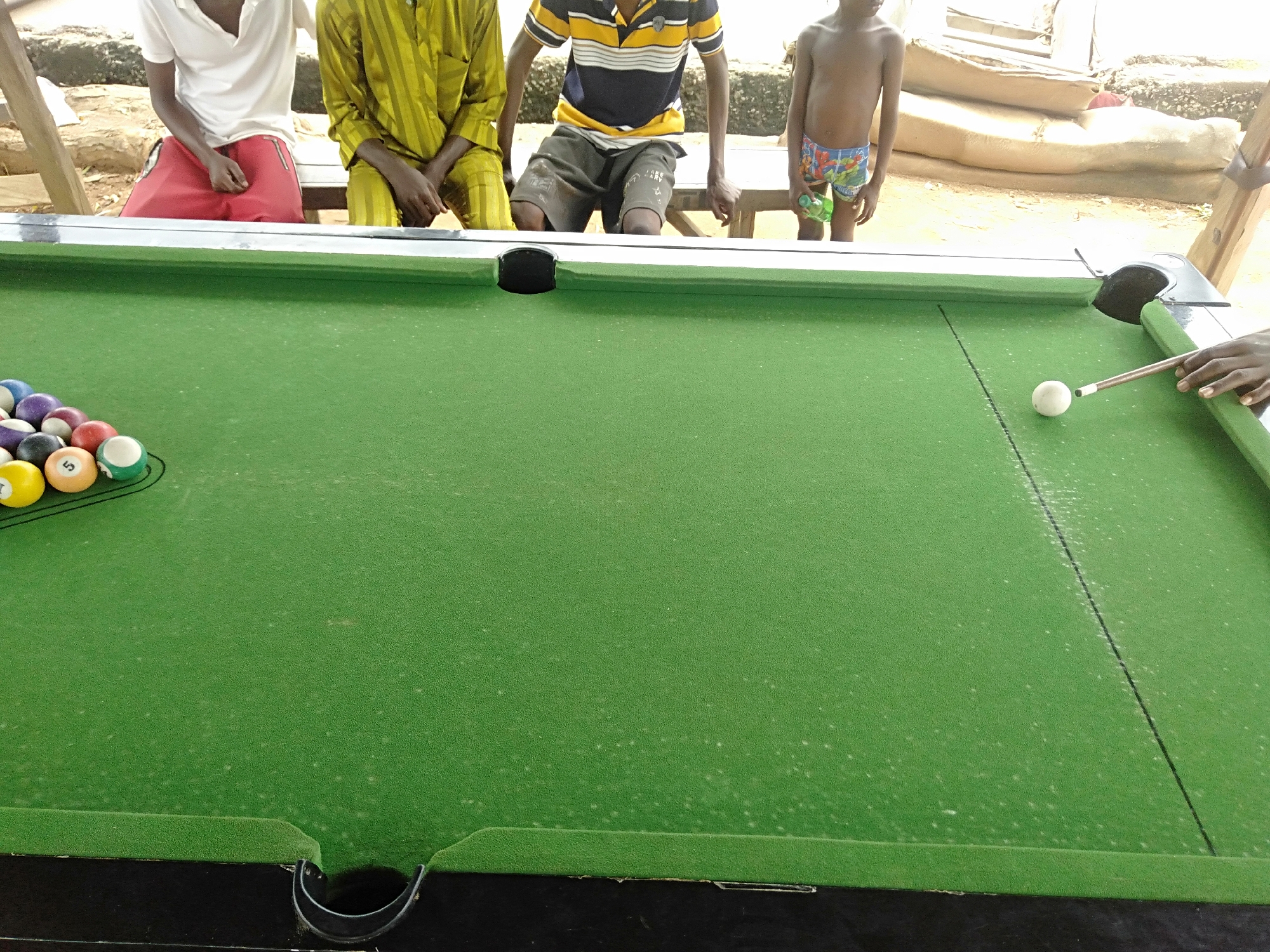 Outdoor pool game captured by witnesses under makeshift shelter