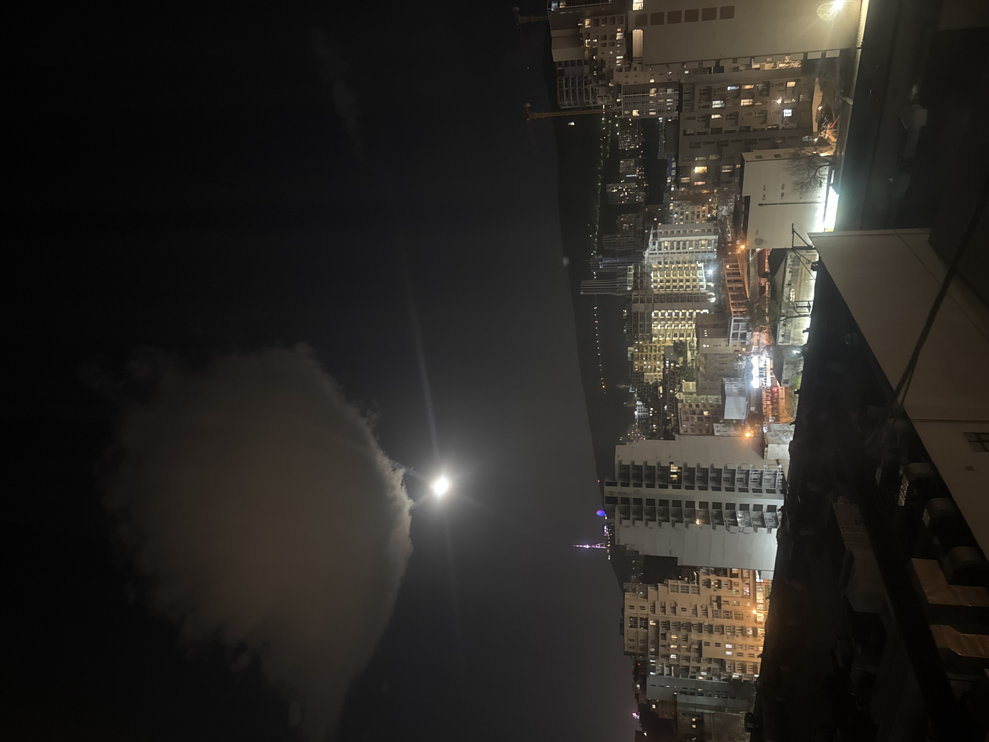 Tbilisi residents document moonlit cityscape during evening hours