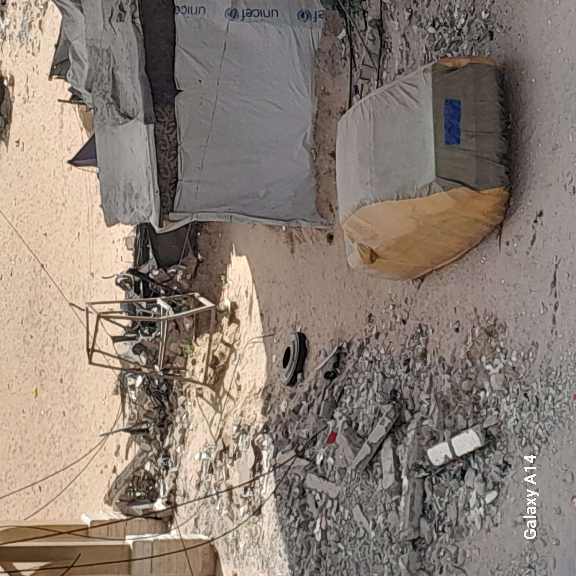 Urban debris scene with UNICEF-marked shelter documented