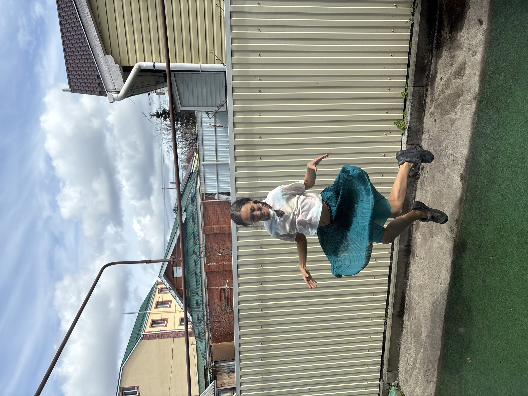 Woman poses and gestures near fence in Ulyanovsk