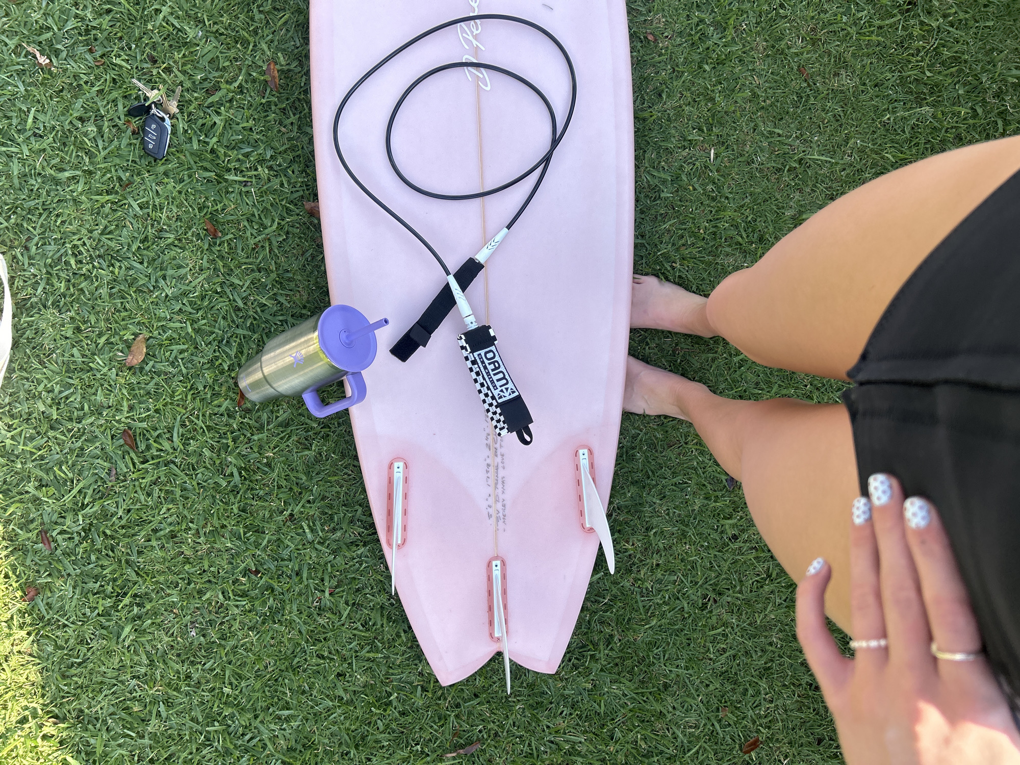 Pink surfboard with gear spotted on grass in Bulli